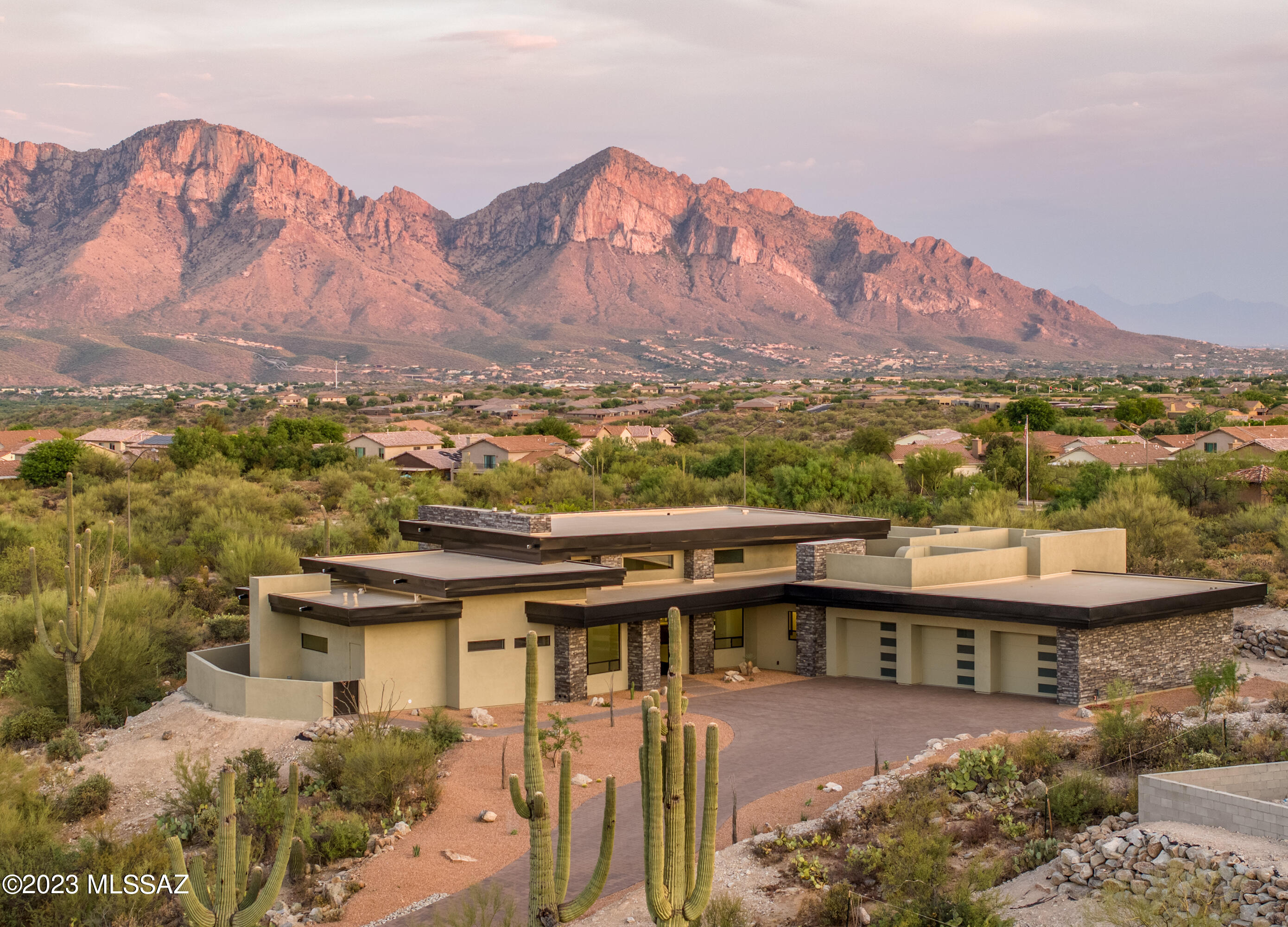 Stunning Contemporary Lines. This East facing elevated property with unobstructed Catalina Mountain views is newly constructed and move-in ready.  Stone Canyon, a secure, gated, private golf club, recreation oriented in a master planned community in Oro Valley Arizona. Long paved driveway leads you to a massive custom metal & glass  pivot door. Upon arrival you see a wall of glass with a stunning Mountain view. Wide open kitchen and great room with large view window from kitchen sink. Wolf & Subzero appliances with island prep sink. Upgraded finishes throughout the home.  Impress your guests with the powder bath which displays gorgeous wood and black toned tile from floor to ceiling. Luxurious Master Suite has a stone faced fireplace, master bathroom has full tile walls, pendant lights at His & Her's vanities and an outstanding walk-in closet beautifully outfitted with custom shelving, drawers and ample hanging space. Large sliding glass doors lead to a private patio with a stunning mountain view. Guest Bedrooms both feature en-suite bathrooms.  Roof deck with unparalleled views south to the city.  Gracious wood ceilings with floor-to-ceiling windows provide a front-row seat to striking areas, pool, spa, water feature. Covered outdoor BBQ with walk in access to large pantry.
