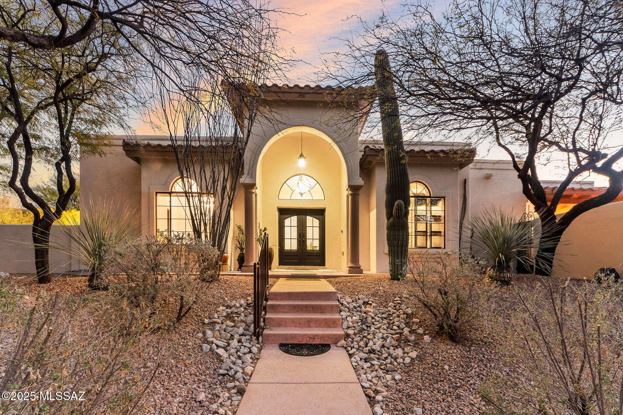 Set in the highly esteemed Star Pass community, this premier residence is the ultimate example of pride of ownership, tasteful elegance, and reverence for the natural surroundings! Steeped in the ethos of Southern Arizona, this one-of-a-kind home blends seamlessly with nature and warmly welcomes! The bespoke steel entry doors open into the foyer and living room further enhanced with a charming fireplace and soaring ceilings adding a degree of grandeur to this warm space! The chef's kitchen is the perfect combination of intentional details and functionality for even the most discerning epicurean. Adorned in quartz countertops, GE Monogram appliances, a triple oven configuration, and custom cabinetry galore, this signature space is the apex of a dream kitchen!
