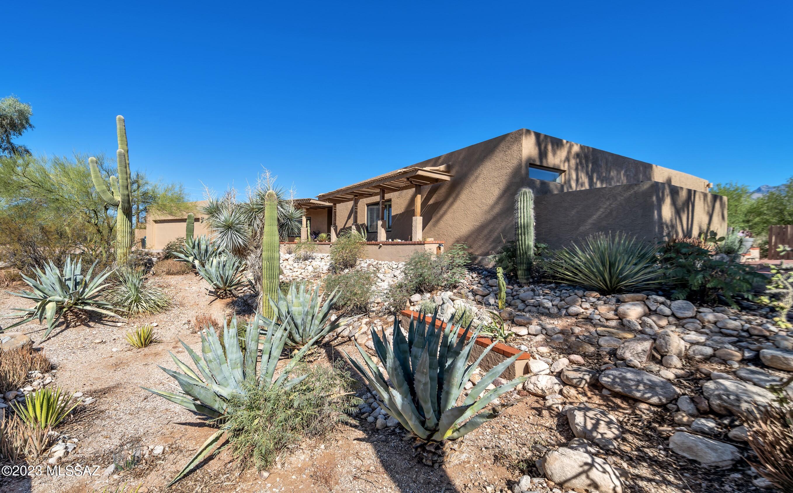 Nestled in the serene foothills, your urban hideaway awaits at the end of a peaceful cul-de-sac. This exceptional property spans approximately 1 acre and can only be described as a ''Botanical Garden'' paradise, featuring a private gully, meticulously cleared walking paths, enchanting sitting areas, ramadas, and an expansive patio. Immerse yourself in the natural beauty of this landscape, surrounded by the breathtaking desert vistas.

The property is graced by the presence of striking blue agaves, elegant palo verde trees, and majestic saguaro cacti that frame the sunrise and sunset views.

Inside, you'll find an open and inviting floor plan that seamlessly connects the dining, den, kitchen, and living areas. A separate wing houses the bedrooms showcasing numerous upgrades throughout. The sunken living room is a true highlight, with a large picturesque window that frames the stunning Finger Rock and Santa Catalina Mountains. Plantation shutters add a touch of elegance to every room.

Practicality meets comfort as the house features a 80-gallon passive solar water heater, ensuring your hot water needs are effortlessly met. The recently epoxy-coated garage includes a connected workshop for your convenience.

The backyard, offering privacy, is an entertainer's dream, perfect for gatherings with friends and family. It boasts a PebbleTec pool, recently recoated cool decking, a fish pond, dual barbequing areas, ramadas, and an expansive patio. There's also an observation deck offering panoramic views of the surrounding natural beauty, city views, and a cozy fireplace for those cool desert evenings. A conveniently located storage shed right outside the backyard wall is perfect for all your storage needs.

This exceptional property is not just a home; it's an oasis of tranquility, luxury, and natural wonder. Don't miss the opportunity to make it yours and experience the best of desert living.