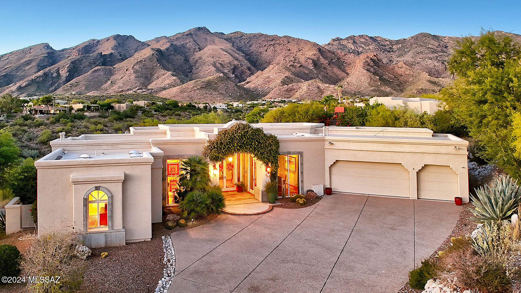 Enjoy majestic mountain views from a custom built G.D.V. home for an interior designer. Open, effortless floorplan with amazing views from wall of glass in every room. High wood beam ceilings, herringbone Saltillo floors . . . all on one level with two steps to two guest bedrooms. The timeless elegance blends seamlessly with modern architectural elements, capturing the essence of the Tucson lifestyle. Gracious outdoor living featuring masonry fireplace, seating area and built-in BBQ. Ideal for entertaining with spacious covered patios and sparkling pool/spa with cascading water feature.
