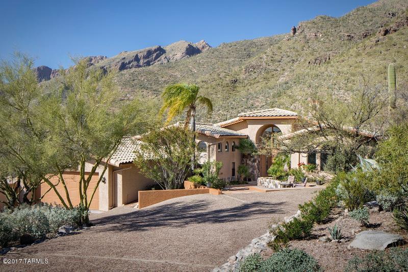 Floor to ceiling windows capture the dramatic views from this gorgeous estate home. The home is set high on a ridge and backs to the Catalina's providing total privacy. Four separate outdoor patios, resort style backyard w/outdoor shower/cabana bathroom. 70' lap pool, hot tub & Ramada w/BBQ, sink, fridge. Gourmet kitchen offers granite counters, custom cabinets, spacious pantry, instant hot water. The private master suite has an adjoining exercise hobby room, sitting area/library, his/hers closets. The luxurious master bath has a dual head shower, Jacuzzi tub, bidet. This quality home has many custom features such as Rolling Shutters, 4 zone HVAC, 2 hot water zones, central vac, game room and views from every window. NO SHOWINGS BETWEEN 5:00 p.m. FRIDAY & 9:00 a.m. SUNDAY.