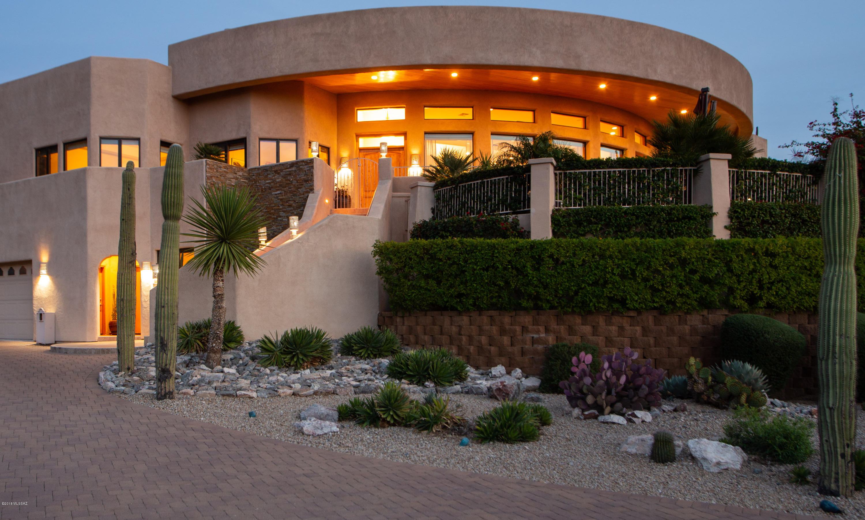 Crisp SW   contemp. nestled in the shadows of the Catalinas in manned gated comm. of Sin Vacas.  Wrap around decks capture the views.  Conv. elevator makes for an easy lifestyle in this two story gem!!  True great room floor plan w/dramatic high ceilings & walls of windows for grand views & light filled space.  Island kit. w/ knotty alder cabs & upgraded granite. Built-in fridge, gas cook top, warming drawer, beverage fridge, & prep sink. Pvt wing w/office (br 2) & owner's suite w/ well appointed bathrm w/ jetted tub, steam shower, w/ access to  spacious deck that can be transformed into interior space (plans avail.) Don't miss ground level guest ste br 5. Covered  patio  melds w/ great rm w/ outdoor kitchen, tv mt, lush plants for extended living area.  Pool & Spa in lush grotto setting.