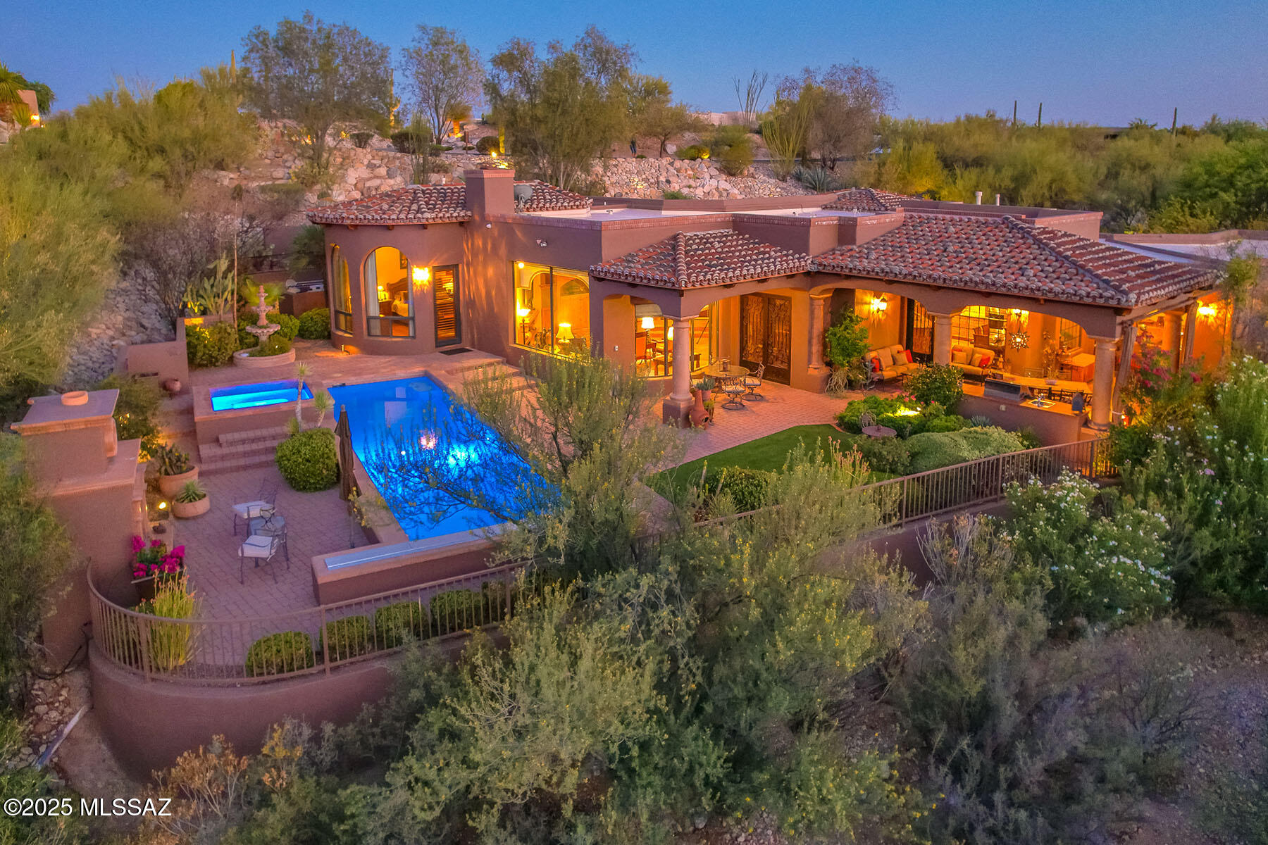 Tucked behind a hill for ultimate privacy, this beautifully maintained 3 bedroom, 4 bath custom home in guard-gated Hacienda Del Sol Estates offers sweeping Catalina Mountain views and a peaceful, secluded setting. Spanning 3,643 sq. ft., the home features a thoughtfully designed floorplan with stone and wood flooring throughout, high ceilings, and generous natural light. The spacious living room centers around a charming fireplace and large picture windows that frame the mountain views. The chef's kitchen boasts granite countertops, a 5-burner Thermador cooktop, wine refrigerator, and ample storage. A formal dining room, separate study with custom cabinetry, and en-suite guest bedrooms add to the appeal. The oversized 3-car garage includes a storage room, workshop sink, and two