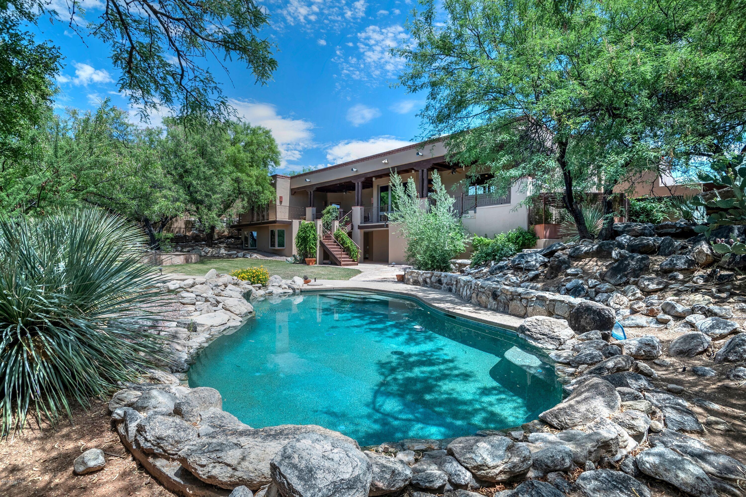 SWEEPING MOUNTAIN VISTAS & SUNSET VIEWS BOARDERING VENTANA CANYON GOLF COURSE. THIS PRIVATE 5 BR 5 BA AUTHENTIC SANTA FE WITH CEDAR CEILINGS AND VIGA BEAMS AWAIT YOU. FINELY CRAFTED LUXURY HOME NESTLED IN GATED CANYON VIEW ESTATES IN DISTRICT 16. THIS STUNNING HOME HAS A SPLIT FLOOR PLAN, VERY TASTEFUL MASTER SUITE WITH GAS BEEHIVE FIREPLACE, SUMPTUOUS BATH AND EXERCISE ROOM. THE AMAZING KITCHEN HAS 5 BURNER GAS STOVE TOP GRANITE COUNTERS CENTER ISLAND AND SOLID ALDER CABINETS. ALL NEW WINDOWS, 3 CAR GARAGE WITH GREAT STORAGE.THE BACKYARD HAS A LAGOON STYLE POOL AND SPA, BUILT IN GAS BBQ, BEEHIVE FIREPLACE & EXPANSIVE COVERED PATIO. WHETHER GATHERING TO ENTERTAIN FRIENDS & FAMILY OR CURLING UP TO ENJOY THE SPECTACULAR SURROUNDINGS AND SUNSETS, THIS REFUGE WILL EXCEED YOUR EXPECTATIONS