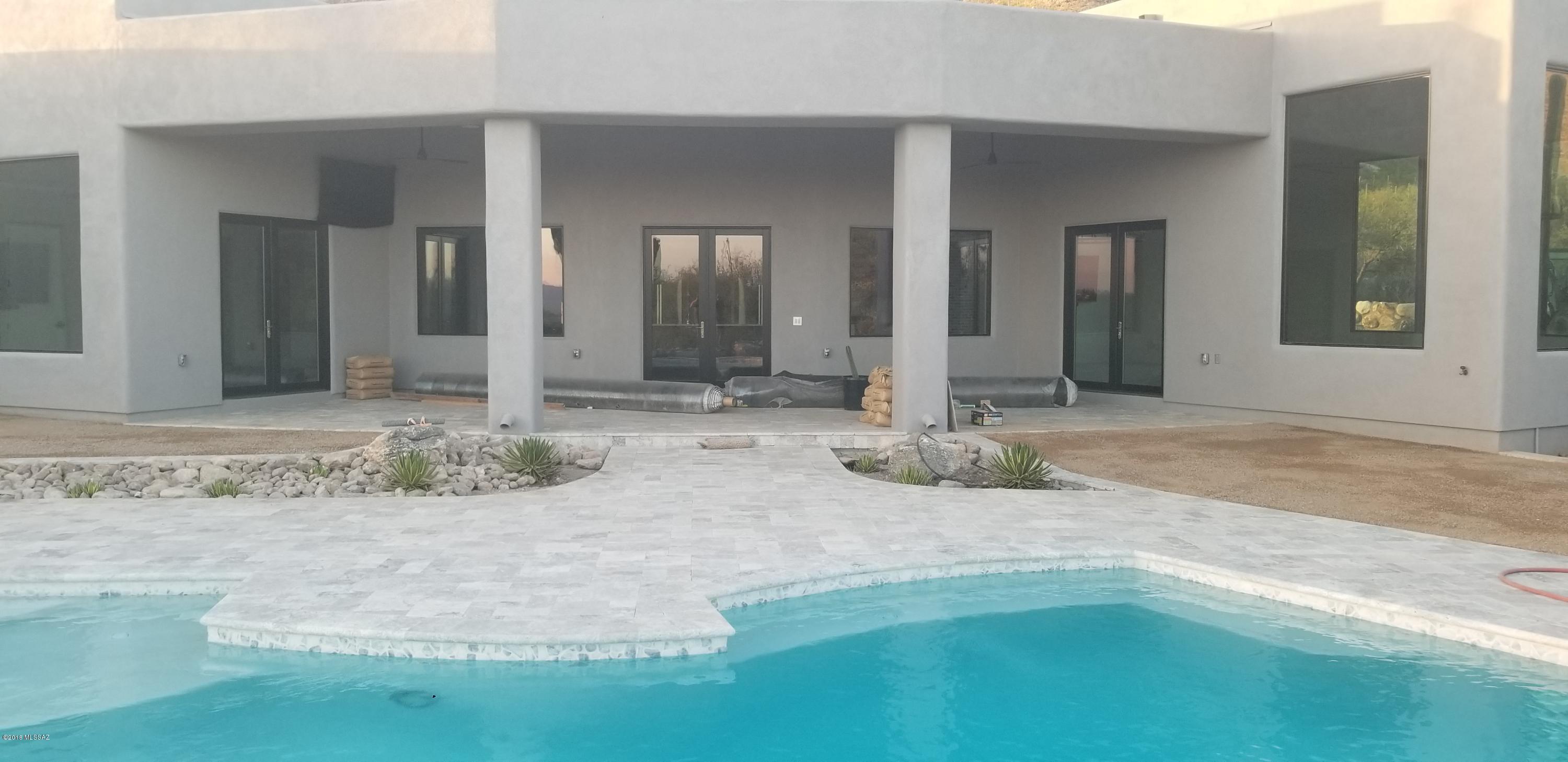 This magnificent stunning custom contemporary home is built for a discerning buyer who truly understands quality in workmanship and value that can only be found in a home built by Bartholomew Homes and designed by Kevin Howard.  Home hosts 5 bedrooms with on-suite baths. Snuggled within the prestigious 24-hour guard-gated community of Pima Canyon in the exclusive reserve enclave. Soaring 16 ft ceilings in the great rm, resort style backyard with pool/spa. High end appliances, lg pantry, wide hallways, handcrafted custom 8ft alder doors throughout. Lg master bath w lg walk-in shower, 4 car garage. Majestic mountain & city views