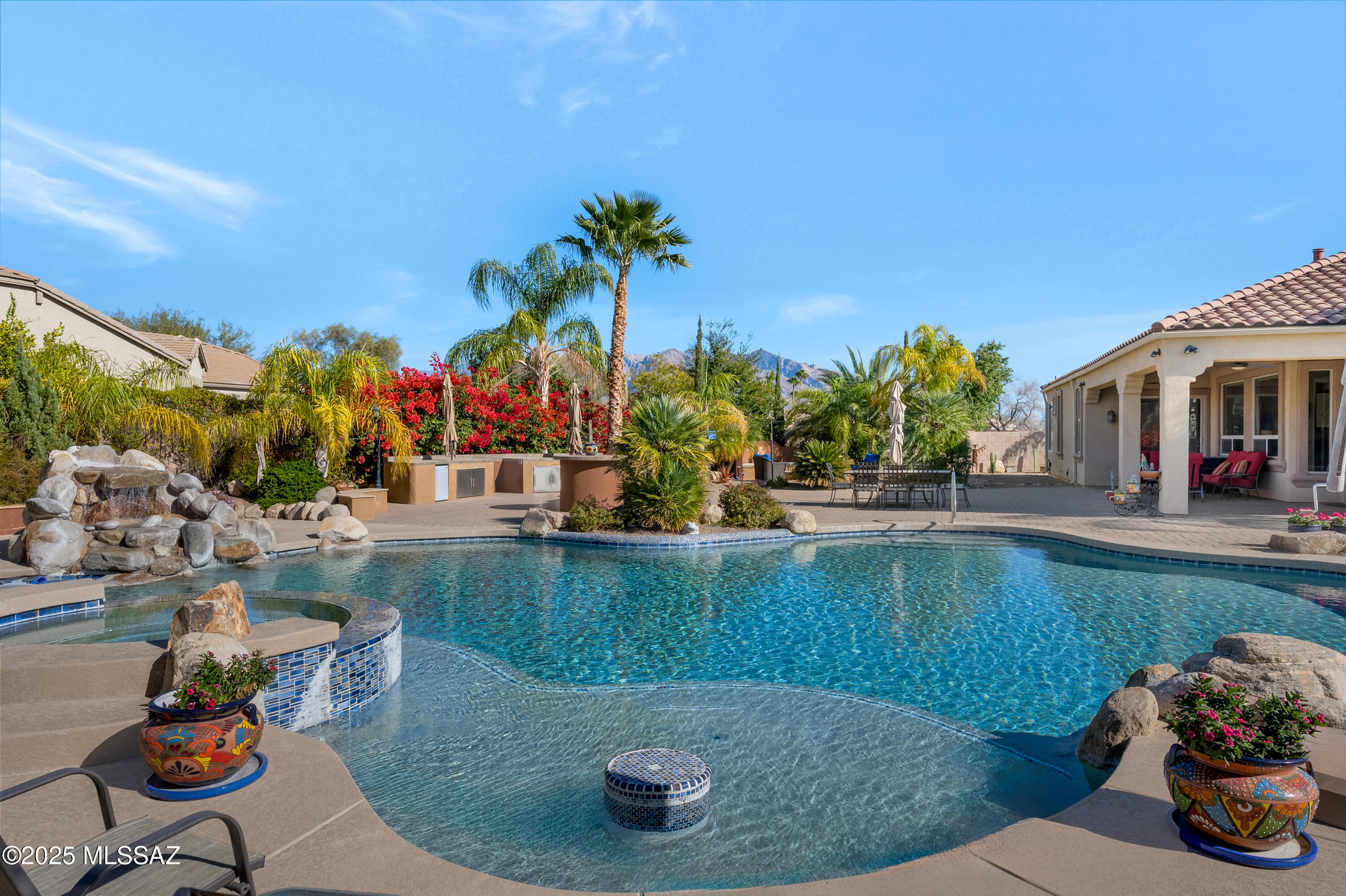 Expect to be impressed the moment you arrive....this home is an entertainer's dream inside and out!  A true desert oasis located within the gated Omni Tucson National Resort! Enjoy a lush resort style backyard that includes an oversized pool and spa, outdoor kitchen, paver patio, and gas firepit with built in seating area. This single story 4 Bed/3 Full Bath semi-custom home on a half-acre lot has been meticulously maintained. The large great room is open and bright to bring the outdoors in. The kitchen includes Quartzite countertops, a large island, stainless steel appliances, extended height cabinets and pantry.  The large primary suite includes, a custom walk-in closet, separate garden tub and shower.  Two of the secondary bedrooms include a jack and jill bath with each having their own vanity and sink.  Additional features include owned solar, 3 car garage, water softener, central vac and so much more!  Great NW Tucson location close to shopping, restaurants, golf, hiking, and easy access to the loop! A must see!
