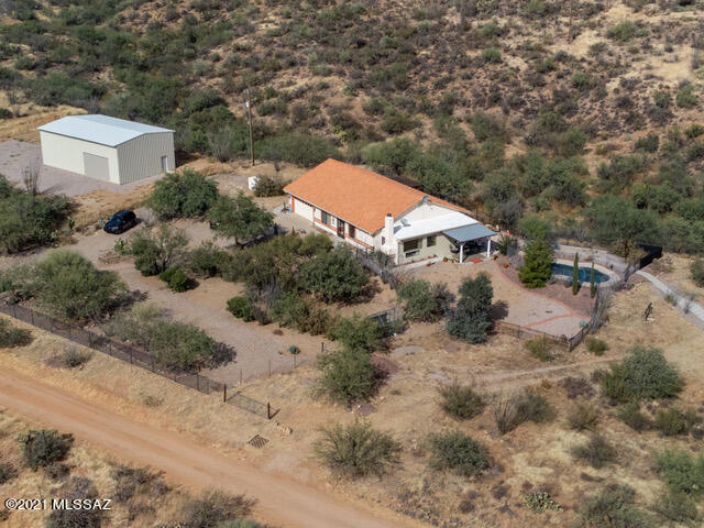 PHENOMENAL MOUNTAIN VIEWS, STARRY NIGHTS, AND A PEACEFUL, TRANQUIL SETTING MAKE THIS CUSTOM HOME ON 9.5+ ACRES AN IDYLLIC SW DESERT RETREAT!  BUILT IN 2006, THIS OPEN CONCEPT HOME OFFERS AN UPDATED KITCHEN WITH STAINLESS APPLIANCES; WALK-IN PANTRY W/CABINETS; A GREAT ROOM WITH ENDLESS VIEWS OF THE SANTA RITA MTNS; 3 BEDROOMS (SPLIT) WITH 2 BATHS; A FENCED YARD AND PEBBLE TEC DIVING POOL; MULTIPLE PATIOS; A DESIGNATED GARDEN AREA; CUSTOM WROUGHT IRON ENCLOSURES AND GATE; A PRIVATE 480' DEEP WELL; AND AN OVERSIZED 2-CAR GARAGE!  IN ADDITION, YOU WILL FIND A NEWLY CONSTRUCTED 30 X 50 (16' HT) ENGINEERED STEEL-CORE BLDG WITH 2 ROLL-UP DOORS THAT CAN HOLD UP TO 6 VEHICLES!  JUST OFF THE BEATEN PATH AND A SHORT DRIVE TO SHOPPING, THIS HIDDEN GEM OFFERS YOU YOUR OWN PIECE OF DESERT PARADISE!