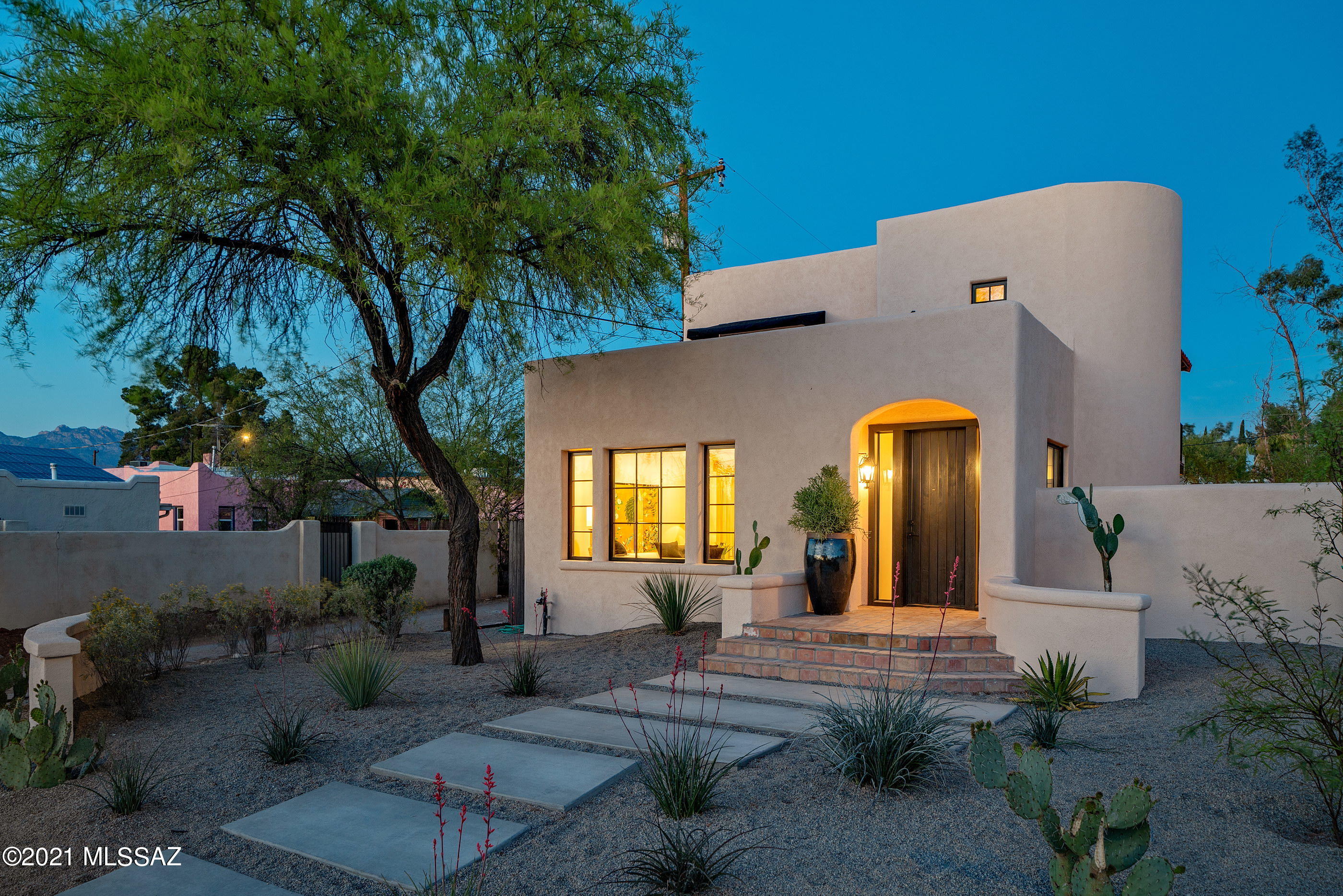 Nestled within the highly sought after historic community of Sam Hughes, a block east of the highly-anticipated Flora's Market Run and a few short blocks from the University of Arizona, this newly remodeled home offers an expression of classic revival vernacular, blending soft interior features, juxtaposed against bold accents. Upon entry, one is greeted with light, space and a dramatic curved staircase. Wide plank oak flooring floats seamlessly through the space.The home's transitional spaces offer the ability to enjoy and entertain effortlessly, with a delicate balance of intimate and public spaces fostering a dynamic living environment. The primary level features a spacious great room concept, encompassing the family room, dining room and kitchen.