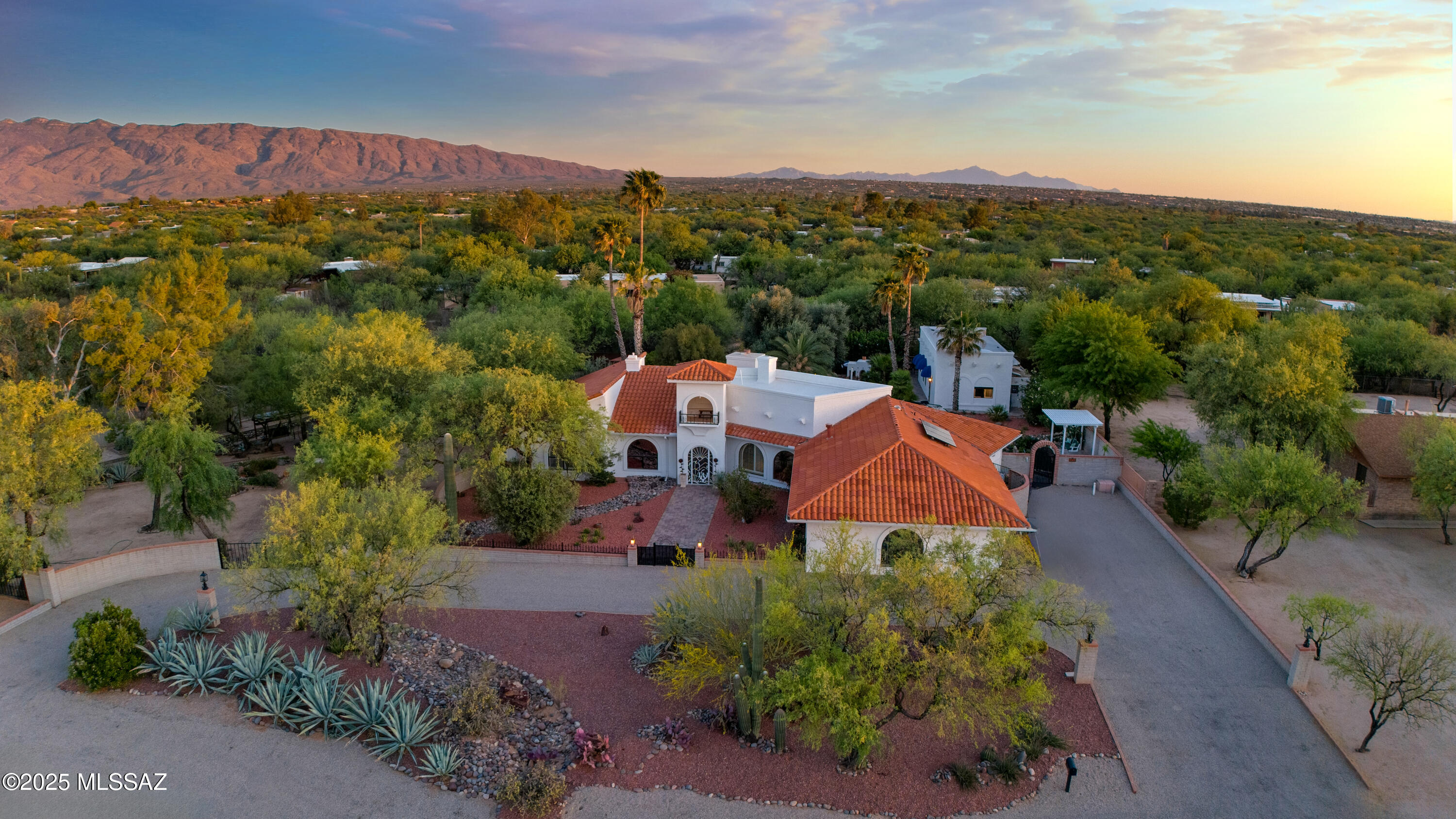 A true naturalist's dream oasis, this Spanish Mission style estate is tucked away on an east Tucson acre. A balanced blend of elegance, style, & amenities accompanied w/ timeless architectural style, a rare masterpiece offering the best of style & nature. The main residence is complete w/ 4 bdrms + 3 bathrooms, along w/  multiple living spaces that usher in natural light & views of the natural surroundings. Private detached guest house is perfect for visitors or multi gen setup. Lush backyard is your own outdoor paradise complete w/ palm, olive, citrus, & other trees w/ vibrant flowers surrounding your travertine pool & spa. PLUS - owned solar panels + rain barrels bring the added benefit of sustainability and lower cost of living. Perimeter is secured w/ block wall or fence adding to your privacy. More....