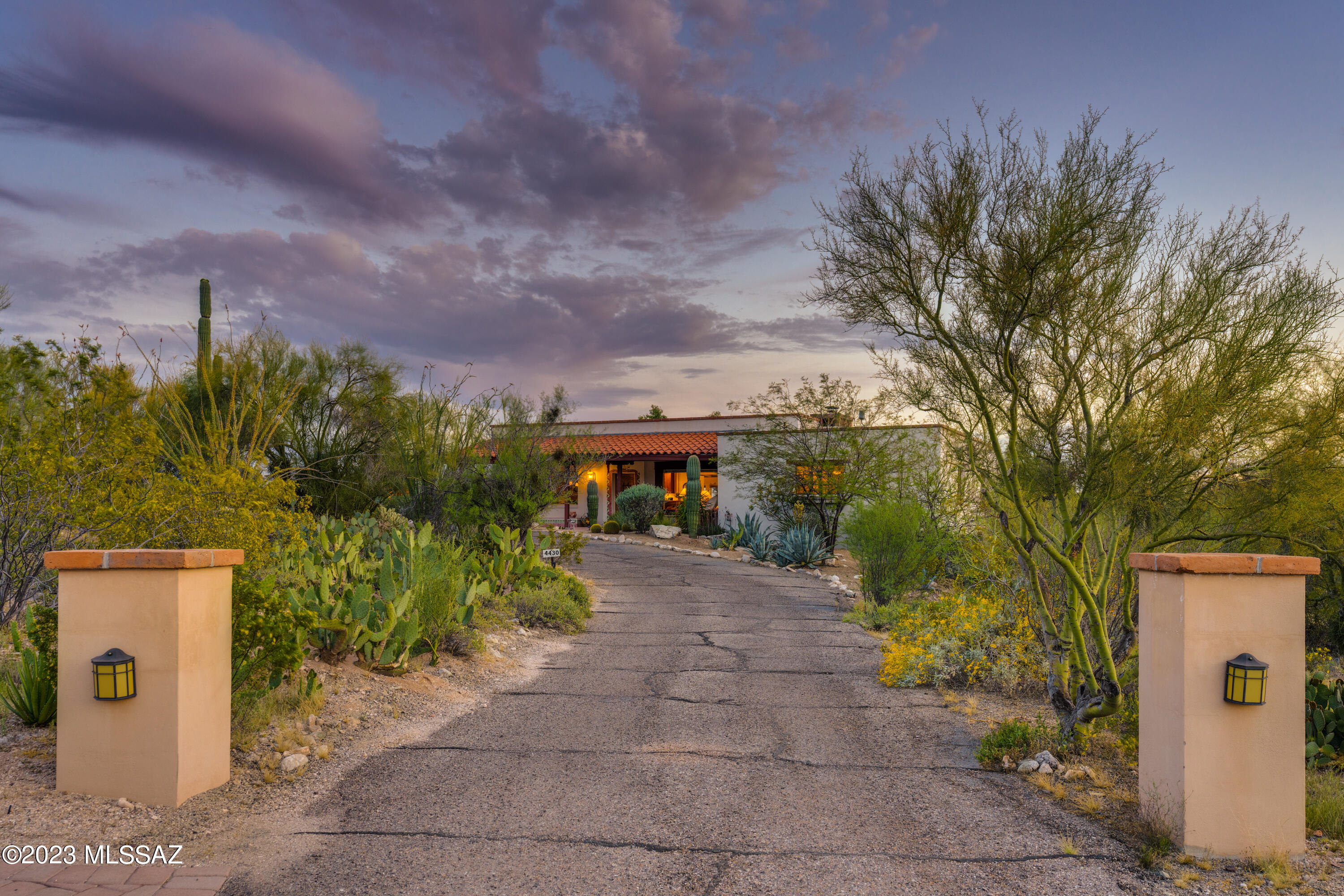 It's a Joesler! A Joesler so tastefully updated that together with its finely crafted Joesler bones it offers comfort and charm while living in harmony with and complimenting a contemporary lifestyle. And the Views! From its hilltop location revel in dramatic Catalina mountain views and wide open city and city lights views to the south. Yes, City and Mountain views!
With its perfect North/South orientation, this home enjoys soft, indirect, natural light. And with a nod to contemporary lifestyles it features an open great-room concept with kitchen, dining and large living area. While mindful that, at heart, it is a Joesler there are authentic architectural details including wood beamed ceilings, adobe walls, stained concrete floors, a Joesler fireplace a covered patio on the north side a comfortable Arizona Room spanning the south side. Delightful south side walled-in yard with easy care desert plantings, a ramada,  a beautiful private pool, a firepit and all of it surrounded by those views.