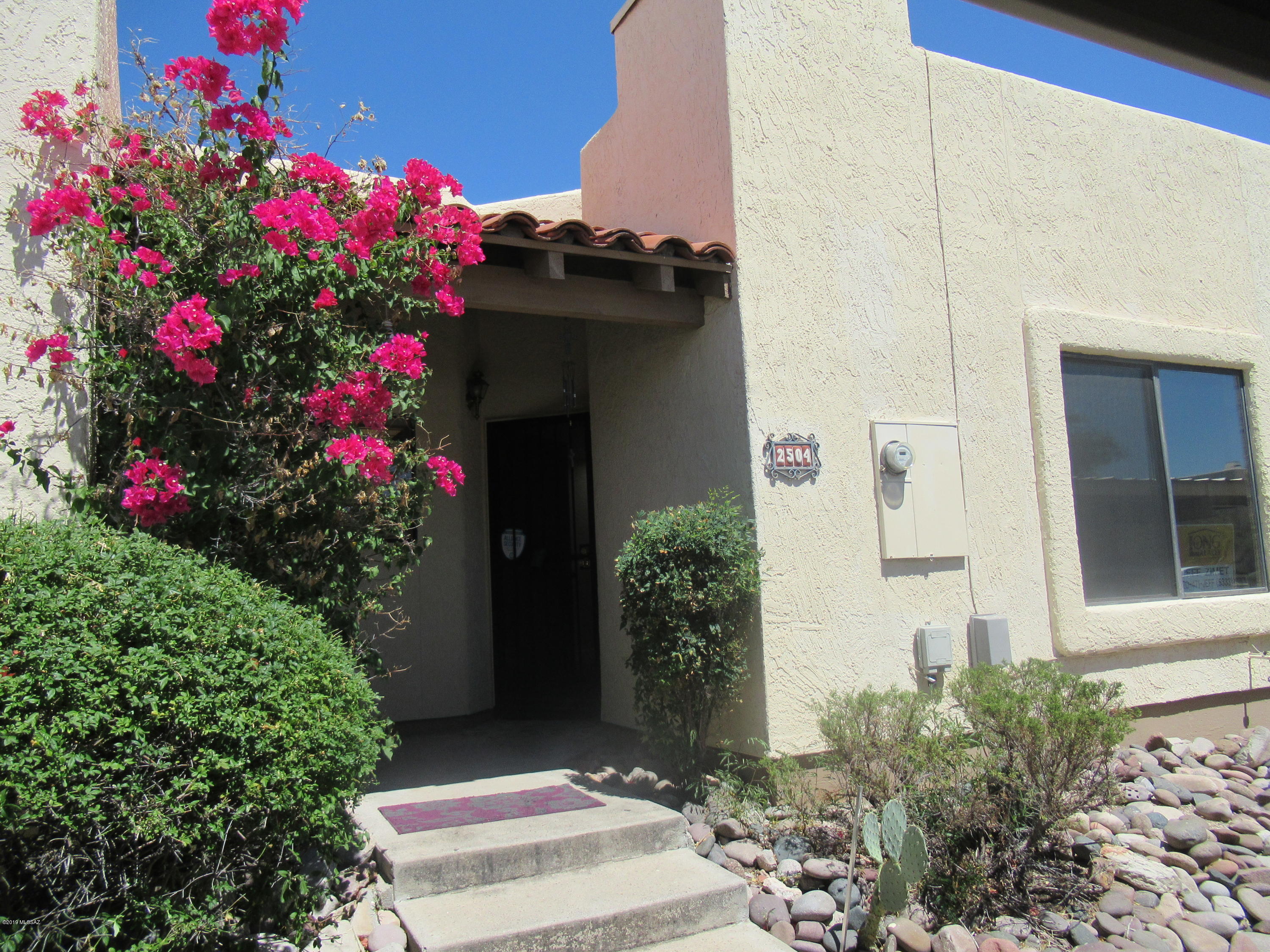 One story town-home in convenient location! Close to U of A, downtown, Pima Community College and I-10. Charming gated community with resort like community pool and spa! Fridge, washer and dryer included! Screened security doors for your comfort and convenience. 2 br 2 bath plus fireplace. Very sensible floor-plan. Small fenced patio to let your dog out. No yard work! Neat, clean and move in ready. Two designated parking spots one is covered.