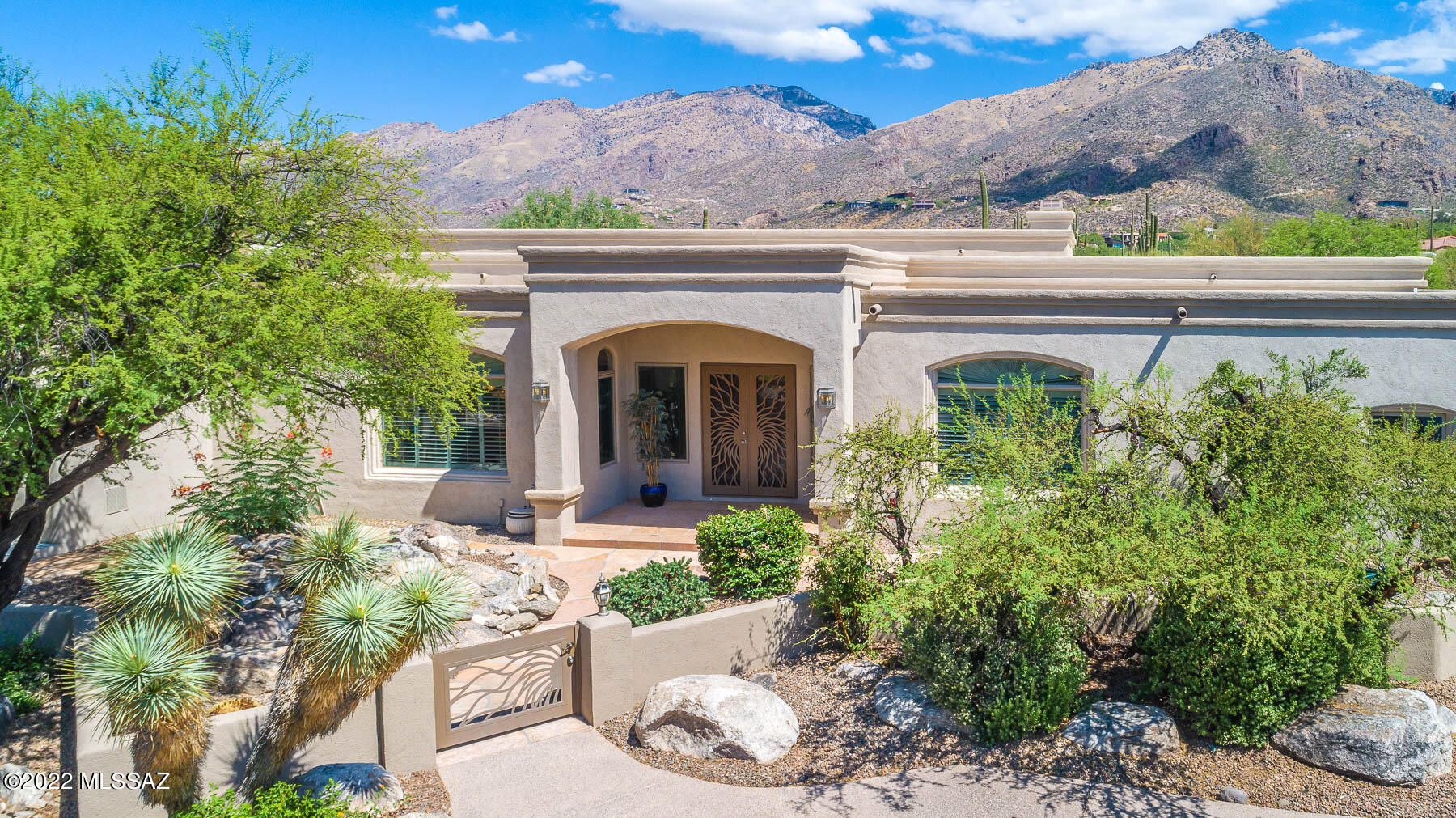 Spectacular Catalina Foothills custom estate with resort-like feel lies in a private, gated enclave. This sale includes two parcels totaling 3.29 acres. Boasting panoramic mountain & city views, this 4BD/4BA (4,449 sq ft) home greets you with a courtyard waterfall. Entertain in the large gathering room with view windows, media wall with fireplace and formal dining room beyond. Gourmet kitchen hosts island w/cooktop, double ovens, Sub-Zero fridge. Luxurious Owner's suite offers view windows, dual vanities, jetted tub, walk-in shower & closet. Second en-suite bedroom/office plus Guest wing w/dual en-suites, den & private patio. Retreat to the rear yard boasting flagstone pavers, covered patio w/grill, heated pool/spa, kiva FP & breathtaking views. Perfect for the most discerning buyer!