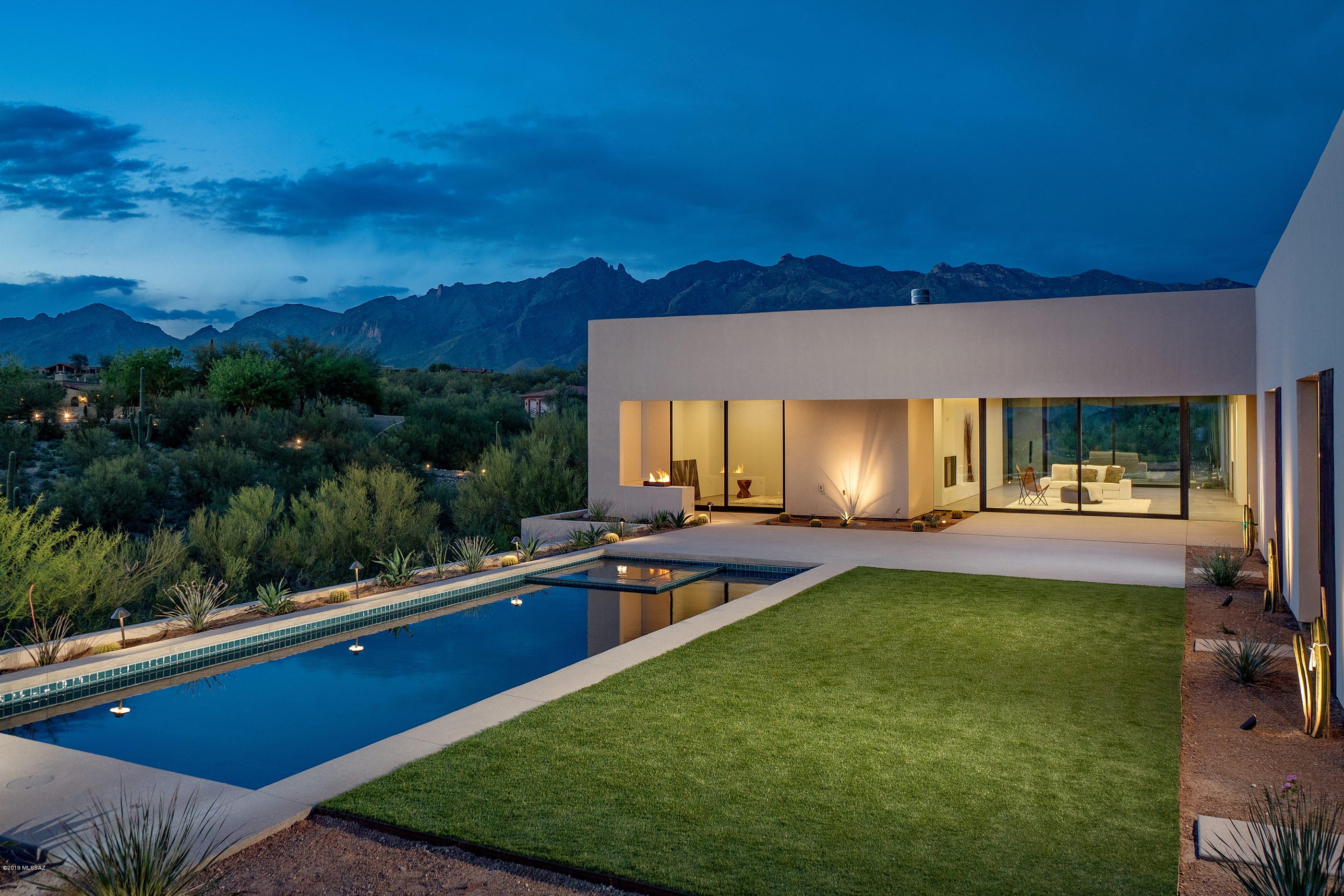 Modern, Luxury and Elegance Defined. Nestled at the end of a quiet cul-de-sac and situated on an elevated lot, this ultra-luxury residence is an expression of modernist lines, with walls of frameless glass, thoughtful proportions, and dimensional massing of space. Enter beyond the home's bold, glass pivot door, into a light-filled and resplendent floor plan, replete with polished concrete floors, smooth finished white plastered walls, and exquisite walnut cabinetry and doors, all providing a visual and tactile experience. The expansive transitional spaces are rich in mobility, with the capacity to enjoy and entertain being effortless, blurring the lines between indoor and out spaces, while bringing the awe-inspiring city and mountain views to the forefront of the experience. A delicate balance of intimate and public spaces foster a dynamic living environment, with 4 en-suite bedrooms that are generous and bright, all discreetly opening onto the rear courtyard, and a private office (or 5th bedroom) with a walk-in closet and bath. The master suite is sequestered on its own wing, offering a combination of luxury treatments, his/hers walk-in closets, and city light views.

This vernacular accentuates the indoor and outdoor lifestyle, with expansive roof overhangs, looking out over the private backyard that has been masterfully designed for entertaining. An integrated pool and spa appear to spill out over commanding views...all coming together to curate a lifestyle of distinct pedigree, in an unrivaled setting.