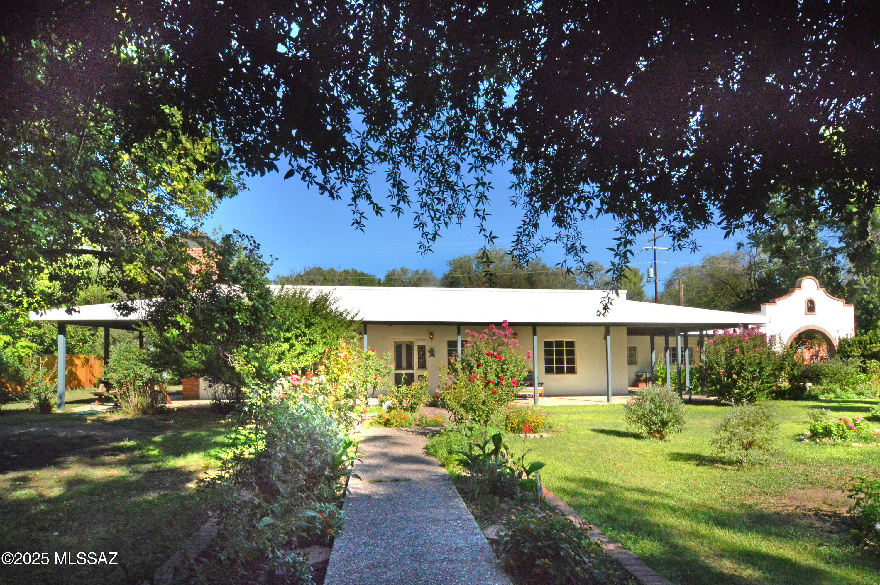 Uniquely designed family home providing 3 separate but complete Residences, each with their own Living areas, Bathrooms & Kitchens, & private entrance, giving each the convenience of personal space. A great home & property setting for intergenerational living & visitors. This c.1962 vintage adobe/masonry family home is in excellent condition & enjoys a floorplan ideal for single or multi-unit possibilities. The 2248sf main residence has 2Be/3Ba w/large Living & Dining areas, Kitchen, Study & 780sf Studio/Apartment. The lush 0.4 acre parcel (2.5+ Town lots) is fully fenced & has Town water & sewer, natural gas + grandfathered PRIVATE WELL. The wooded grounds & mature plantings are lovely & the overall park-like setting ideal for all variety of gardening interests & other special projects.