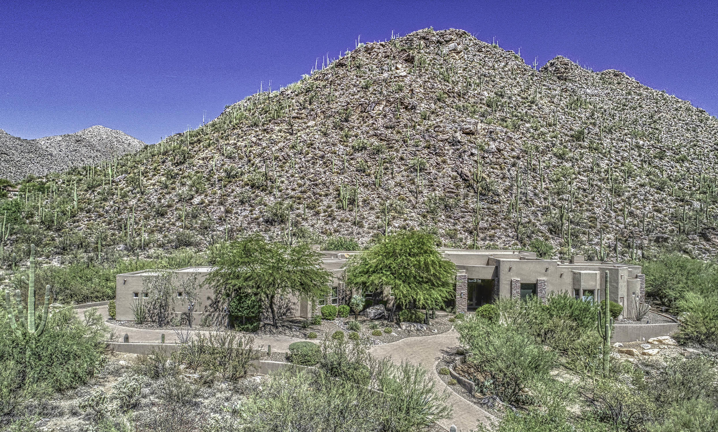Stunning home in exclusive Canyon Pass at Dove Mountain community. Breathtaking views and Spectacular Outdoor Spaces! Exquisite home details include natural stone and wood flooring, gorgeous granite countertops, custom woodwork, stacked stone fireplaces and accents.  Oversized automatic doors open the home's living area to the spectacular multi-level backyard showcasing the privacy and expansive mountain views! Enjoy the pool, fountain, fire-pit and putting green.  The chef's kitchen is a dream with Viking appliances, wet bar and temperature controlled wine room.  Large family room with fireplace; custom built office; formal dining area; bonus room in the oversized garage. Incredible master suite and bath are sure to impress. Luxurious and comfortable, this amazing home has it all!