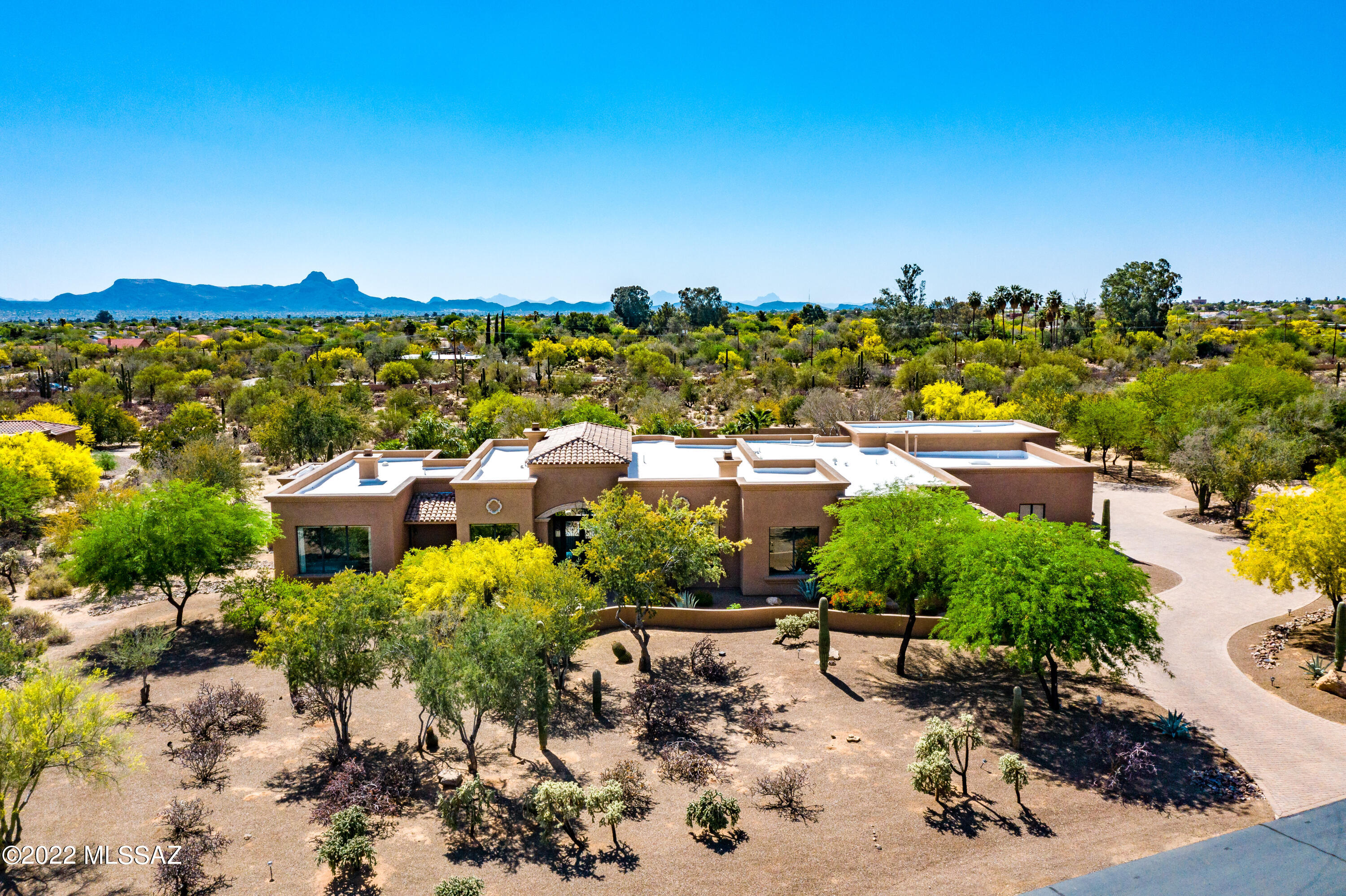 A rare find in NW Tucson - this spectacular, spacious, sprawling single story luxury custom home on 3.3 acres boasts one of the most fantastic  backyard living and entertaining setups one can imagine. heated pool, spa, fire pit seating area, fireplace gathering, Tiki hut kitchen and BBQ area, pickle ball, sand volleyball, turf area for pets and kids, and a massive roof deck large enough to host a massive graduation party!  Inside the stunning home one will find a chef's kitchen with beautiful remodeled countertops and chic lighting. Homes exterior was just repainted in April 2022.  Home is well maintained, the grounds are gorgeous, and the interior can host a plethora of residents/guests.  Small,  gated enclave subdivision. Tucson Omni access with property ownership.