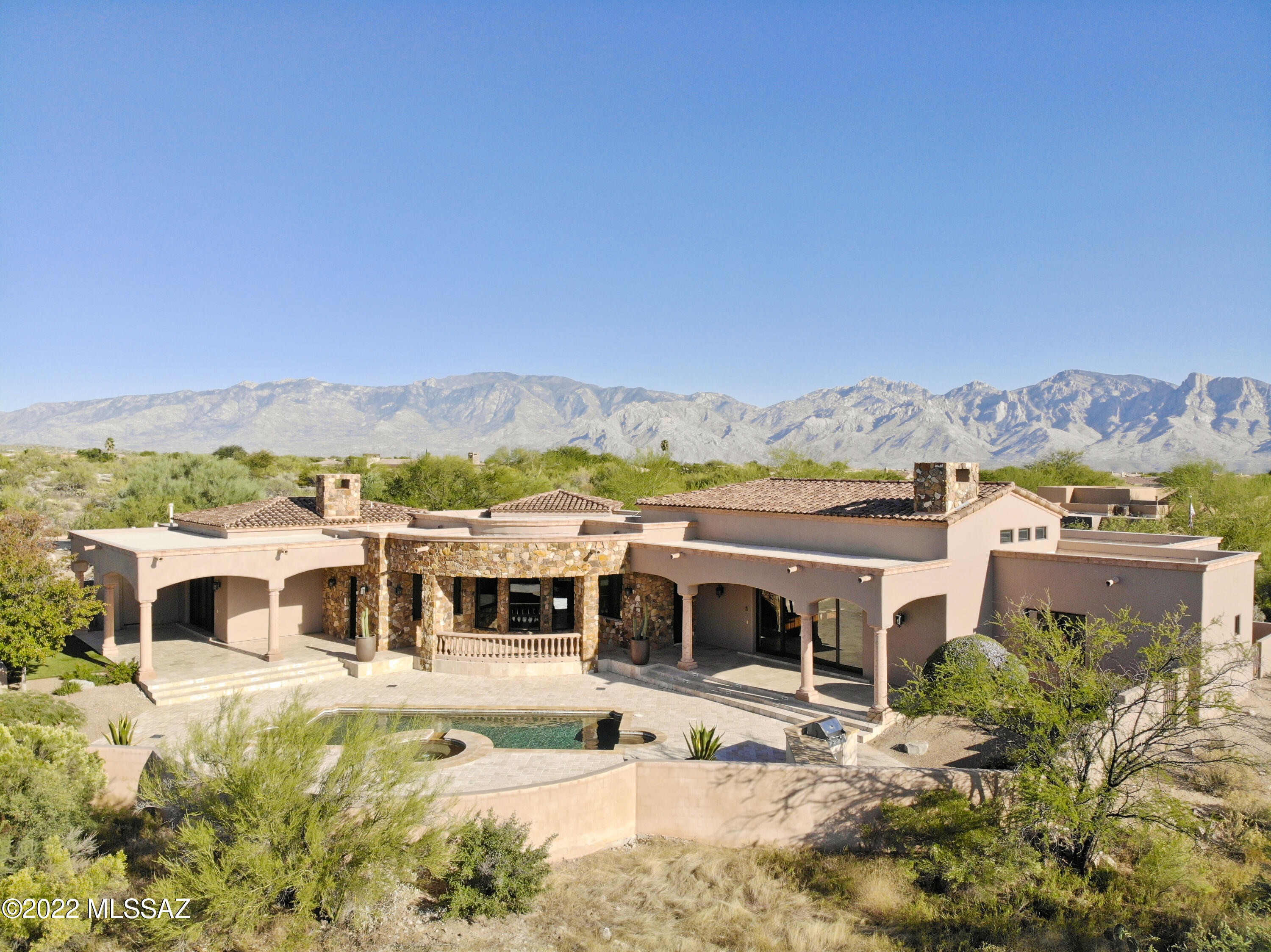 Nestled in the prestigious gated, Top 100 golf community of Stone Canyon is this GORGEOUS Mediterranean inspired custom residence! The just renovated primary suite includes ultra-luxury touches that rival any resort spa, including a bookmatched granite slab steam shower, towel warmer, and 104'' Kohler infinity edge tub! The bedroom showcases pocketed motorized blackout drapes, inset coved ceiling, and extensive kitchenette, while an adjoining exercise room rounds out the owner's suite. The rest of the home offers equally impressive details like a commercial Viking range, temperature controlled wine cellar, open great room w/soaring ceilings, Sonos sound system, coffered ceiling dining room, grand living room, stunning Tortolita Mountain views, refreshing pool/spa, and travertine floors.