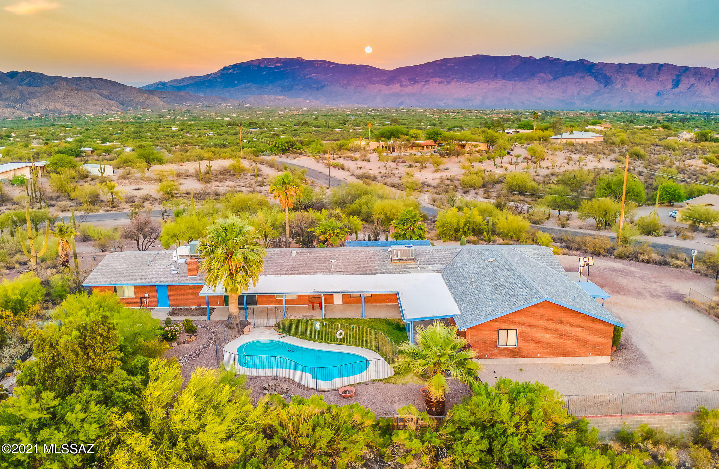 Perched high on an 3.4 acre elevated lot, this NE Tucson ramblin' ranch offers panoramic views of the majestic Santa Catalina, Rincon, Santa Rita and Tucson Mountains. Imagine Sunrises, Sunsets, and the Night Sky filled with stars and city lights. Sprawling 5,082 SqFt brick home with attached 2 Bedroom Guest House = Amazing Indoor/Outdoor Living and Entertaining Space! Seven Bedrooms, Two Bathrooms, Two Owner EnSuites (in main house), Gated Pool, Full Length Covered Patio, One Car Garage with Off Street Parking. Perfect as multi-generation home, assisted living facility, AirB&B, corporate retreat. Ideal for those who need extra work/play room, the hobbyist that requires space and storage, and those with in-home businesses. Time and TLC can bring back the former glory of this serene estate!