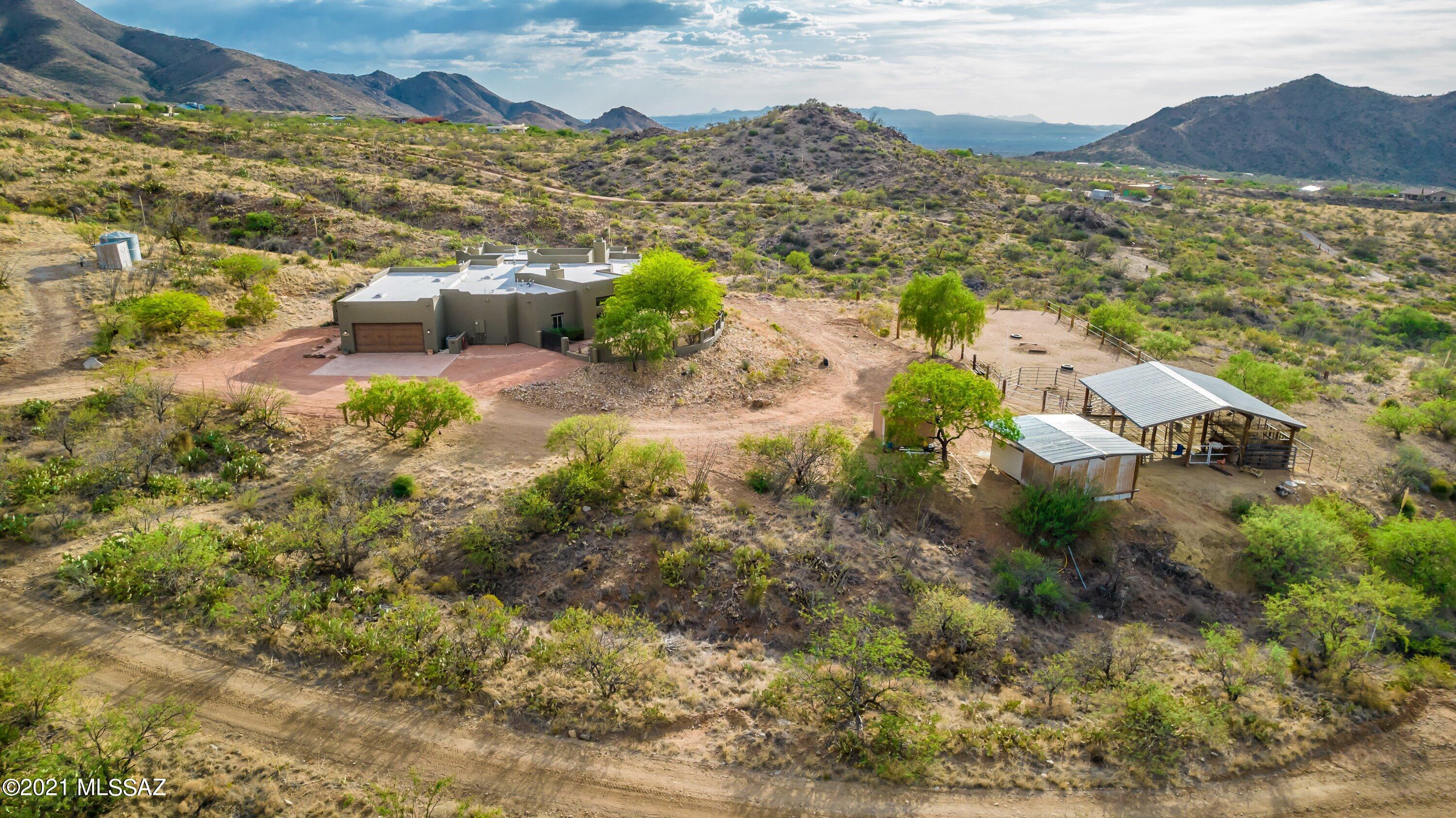 Sellers are RE Agents of Southern AZ .Beautiful 5 Bedroom,3.5 Bathrooms on 4.99 AC  up in the Santa Rita mountains over looking the city lights of Tucson.Kitchen has granite counter tops with double baking/Convection ovens.Large pantry closet, great room and dinning area,fireplace. Beautiful picture windows for the views.  Formal Living room, M-Bedroom has fireplace ,large bathroom with whirlpool Tub, large walk in closet. Split floor plan that has a private bathroom and bedroom that could be used for guest .Has a private well. Horse property with facilities .. This home is in the desired Vail School District. Garage was originally a 4 car garage but turned two of the bays into a home office could be easily changed back . garage has a storage room . Water softener. and much much more!!
