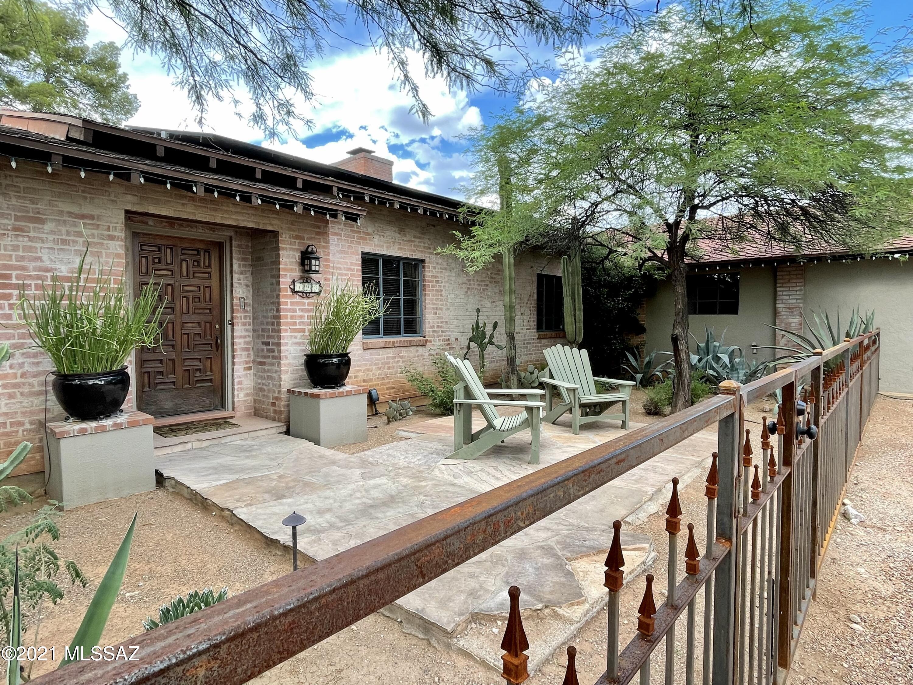 Nestled in the Historic Catalina Vista Neighborhood, this lovely brick home with guest house offers the best of central Tucson. Hardwood floors, two charming fireplaces, and Saltillo tile exude character, while large windows offer sweeping views of the maturely landscaped yard. The Split floorplan has two bedrooms and two bathrooms at one end and a large primary suite situated for privacy. The expanded kitchen has granite counters, gourmet appliances, and island seating. Two car garage, large pool, synthetic lawn, and flagstone patio. Minutes to the the University of Arizona, Banner Hospital, and Downtown Tucson.