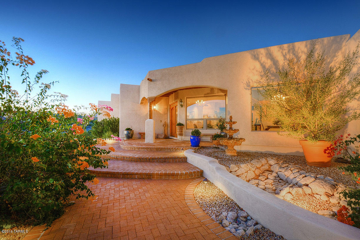 Spectacular City & Mountain Views from this premium elevated lot in Cimarron. This quality built Santa Fe home has 4 BR/3 BA with new exterior & interior paint. Enter thru the foyer with sitting area to the formal living room with custom fireplace and picture windows. Enjoy Tucson city lights from the elegant formal dining room. Open cook's kitchen has granite counters, new induction cook top & double ovens.
Cozy family room off kitchen has exposed wood beam ceiling with fireplace and built-in shelving. Spacious master bedroom with sitting area, fireplace, California closets, and luxurious master bath with jetted tub. Beautifully landscaped back yard features sparkling pool & spa, expansive covered patio and separate raised patio area for entertaining.