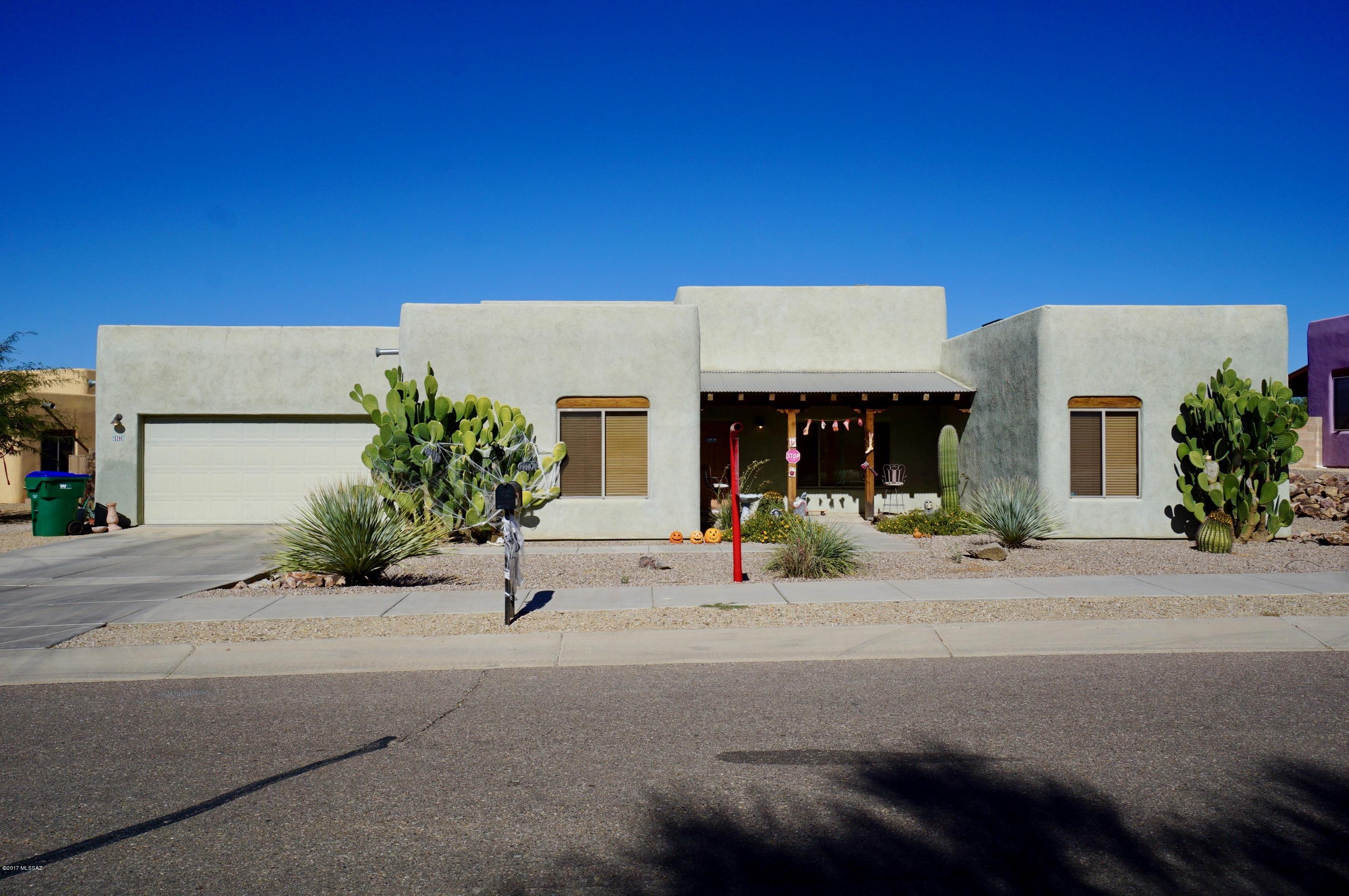 Enjoy a touch of the Southwest in this Santa Fe style TJ Bednar home in Eagle Point Estates. Custom wood beamed ceilings, Saltillo tile floors grace all main areas. Inviting beehive fireplace in living room. Kitchen with breakfast bar, upgraded cabinets, tile counter tops and backsplash. Spacious master suite, split bedroom floor plan, 3 Bedrooms, 2 Baths. Spacious enclosed backyard with covered patio and gas BBQ stub. Tucson Mountain views. 2-Car garage. Convenient to I-19. Clean and move in ready!