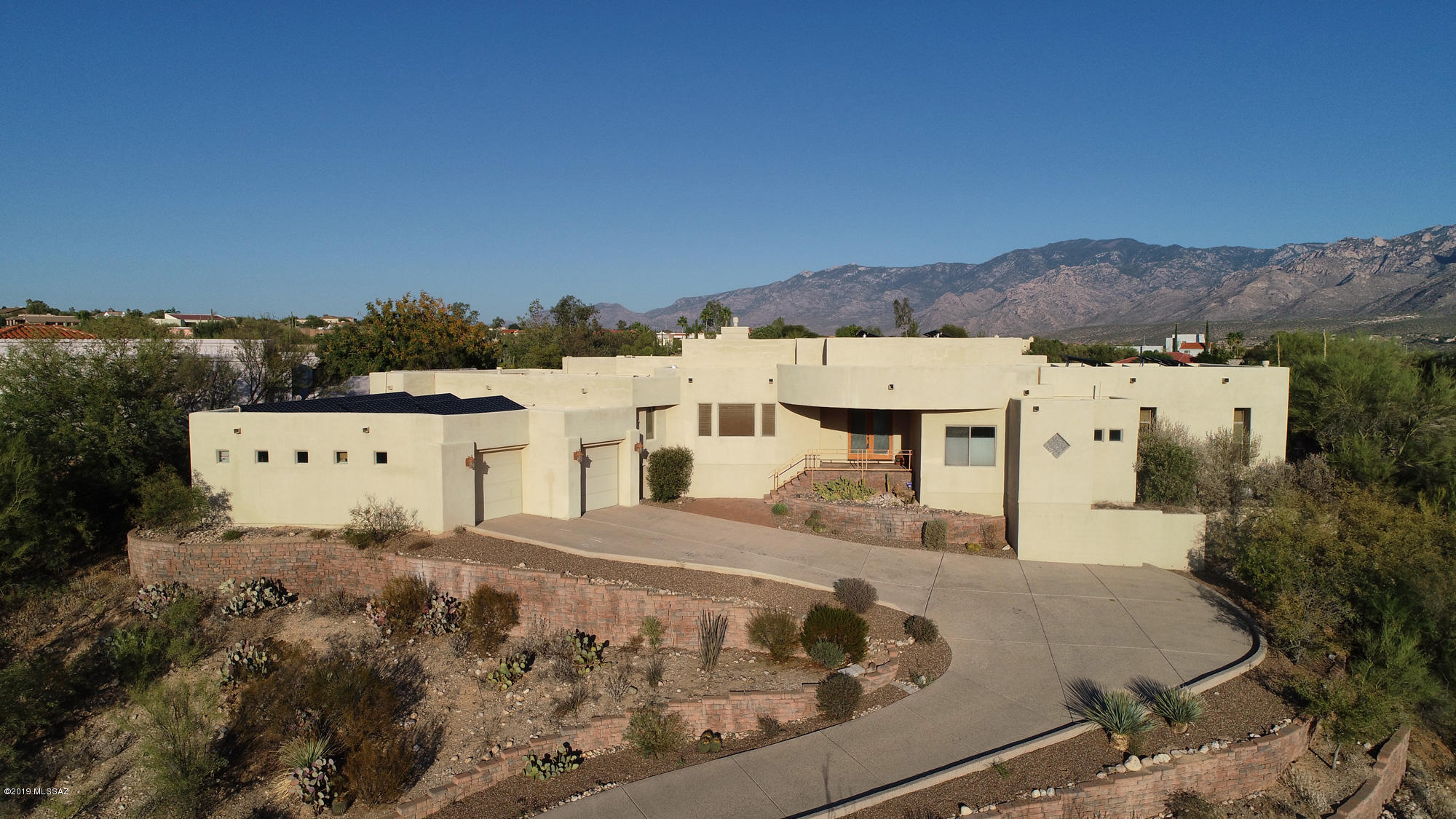Relax in your infinity edge pool and jetted spa while enjoying can't-miss-it forever views of dramatic  Pusch Ridge and the Catalina Mountains. Or would you prefer a soak in your outdoor Dead Sea mineral bath in your Zen-like garden, or perhaps practicing your putt on your own green? Or just relax on your cool misted terrace....all are options in this hillside home designed by respected architect Marc Solloway and featuring his creative coffered ceilings throughout the home. Enjoy a relaxing lifestyle in Oro Valley's gated and highly desirable Canada Hills Estate, in a lovely open plan home with stunning mountain views from plentiful windows and lots of room for family gatherings and entertaining. Prepare meals and gather with friends and family in the spacious kitchen around the large butcher-block topped island with sink & wine storage, and enjoy lots of granite-topped counter space, a second sink, and walk-in pantry. The focal point of the adjacent family room with fireplace and dining room is the spectacular mountain views seen over the pool and spa. The master bedroom includes more views along with a spacious master bath providing  large Jacuzzi garden tub,  double counters topped in granite, a make-up counter AND an uber-cool shower with double shower heads, built-in long bench, and its' own overhead heater to keep you cozy on chilly mornings. A fabulous family room/bonus room that includes a wet bar, movie projector and surround sound speakers provides a welcoming spot for quiet relaxation by the large fireplace or a gathering spot for a crowd (A game of pool, perhaps?) ....oh, and did we mention the views? A fabulously oversized garage can accommodate four vehicles (tandem) with plenty of space for storage and workbench. Bonus: A fully-owned 10.56kW solar system (rooftop, 32 panels) and almost ZERO electricity bills, built-in vacuum system, home fully wired for sound; fire sprinkler system and full home ethernet wiring; and the entire back terrace has a misting system for those hot summer days.  You're in the heart of Oro Valley with easy access to shopping, restaurants, entertainment, fitness studios, great hiking and biking, and medical services including the Oro Valley Hospital just minutes away.  If this sounds like your kind of living, you are invited to call today for a private showing. Roof has just been re-coated (December 2019) with a transferable three year warranty!!