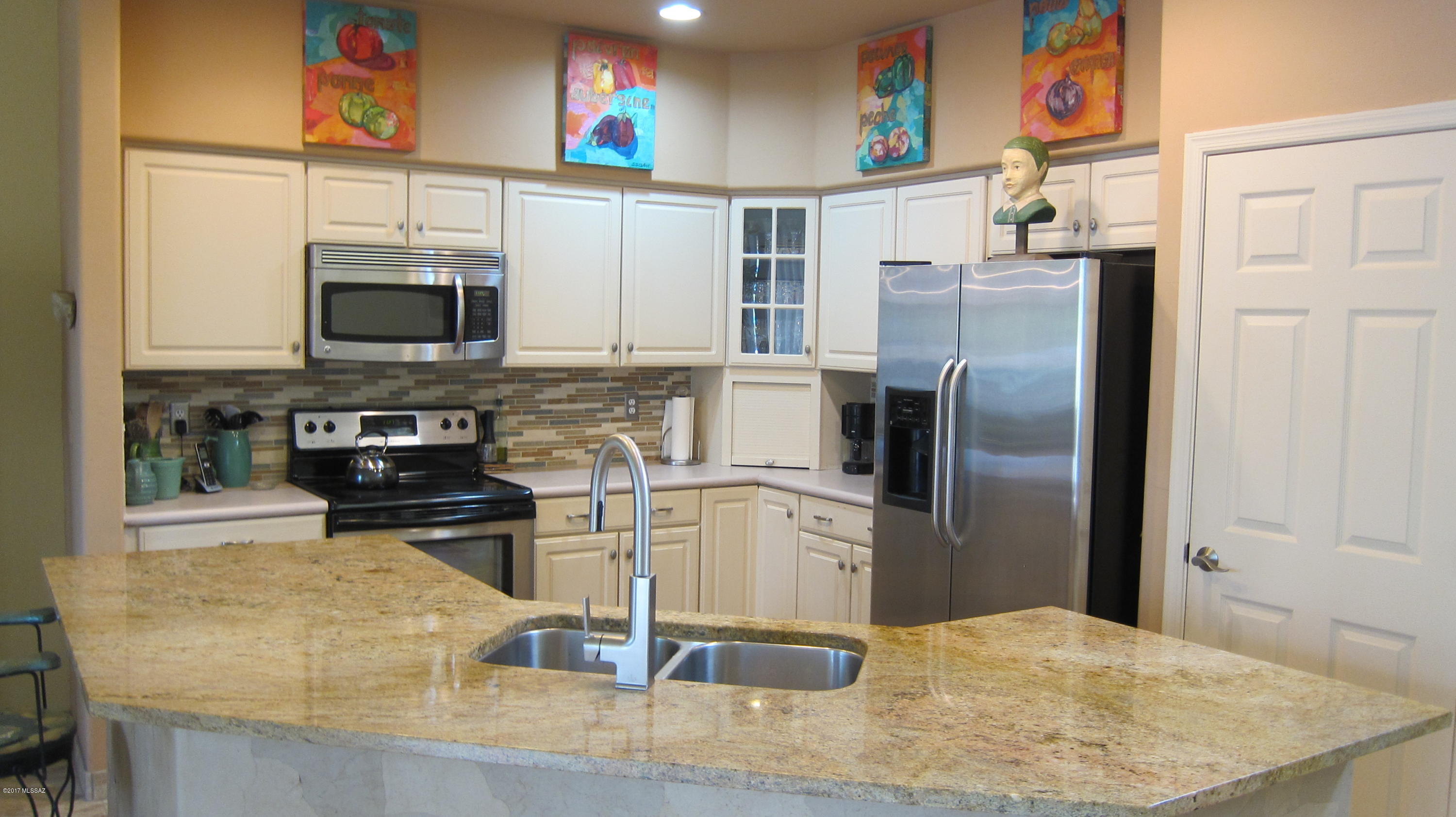 Great town home in the Omni Tucson National community.  Beautiful VIEWS of the Catalina Mtns. with east facing backyard.  Nice updating with travertine flooring in entry through great room and kitchen and guest bath.  Travertine surround on fireplace. Large granite topped island for food prep and serving.  Wall bed in second bedroom stays.  Two sinks in master bath, walk-in closet, large shower.  Clerestory windows in great room, many skylights for extra light.  Beautiful paver patio for easy living.  Heated community Pool and Spa nearby that are in HOA fees.  The Omni resort has two world-class 18-hole golf courses, tennis courts, pools, restaurants and many other amenities.  Various membership plans available for Omni.