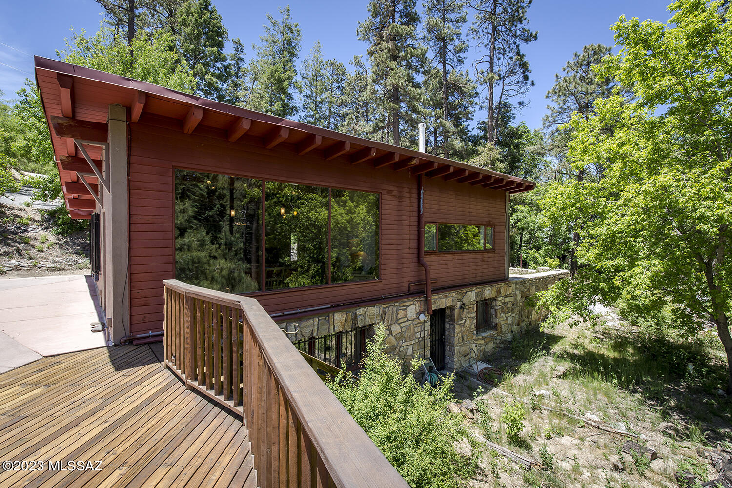 Mount Lemon retreat, Immerse yourself in the beauty of nature while enjoying the tranquil sound of a nearby stream, these cabins are perfectly situated for enjoying all that Mt. Lemon has to offer. Explore the nearby trails, go hiking or biking, skiing or simply enjoy the cool mountain air. Situated on a beautiful 1.4-acres surrounded by picturesque pine trees, bordering National Forest and comes with riparian water rights from the natural spring. The 2400 sqft main cabin offers large pine beam ceiling, hand quarried rock fireplace and a large picture window providing awe inspiring views of the surrounding forest. The spacious kitchen is easy to entertain large gathering and two large dormitory style bedrooms accommodates 10 or more . The detached guest cabin offers 922 sqft of  a -- additional 3 bedrooms and 2 bath (built in 2005). This unique set up of two cabins allows for a great multi generational family compound, vacation rental or retreat can accommodate 16 or more easily . The convenient proximity to the town of Summerhaven , only 5 minute walk away with the ever expanding amenities ensures that you can easily access restaurants, shops, and entertainment options. The paved and winter plowed roads to driveway allow for easy access year round.