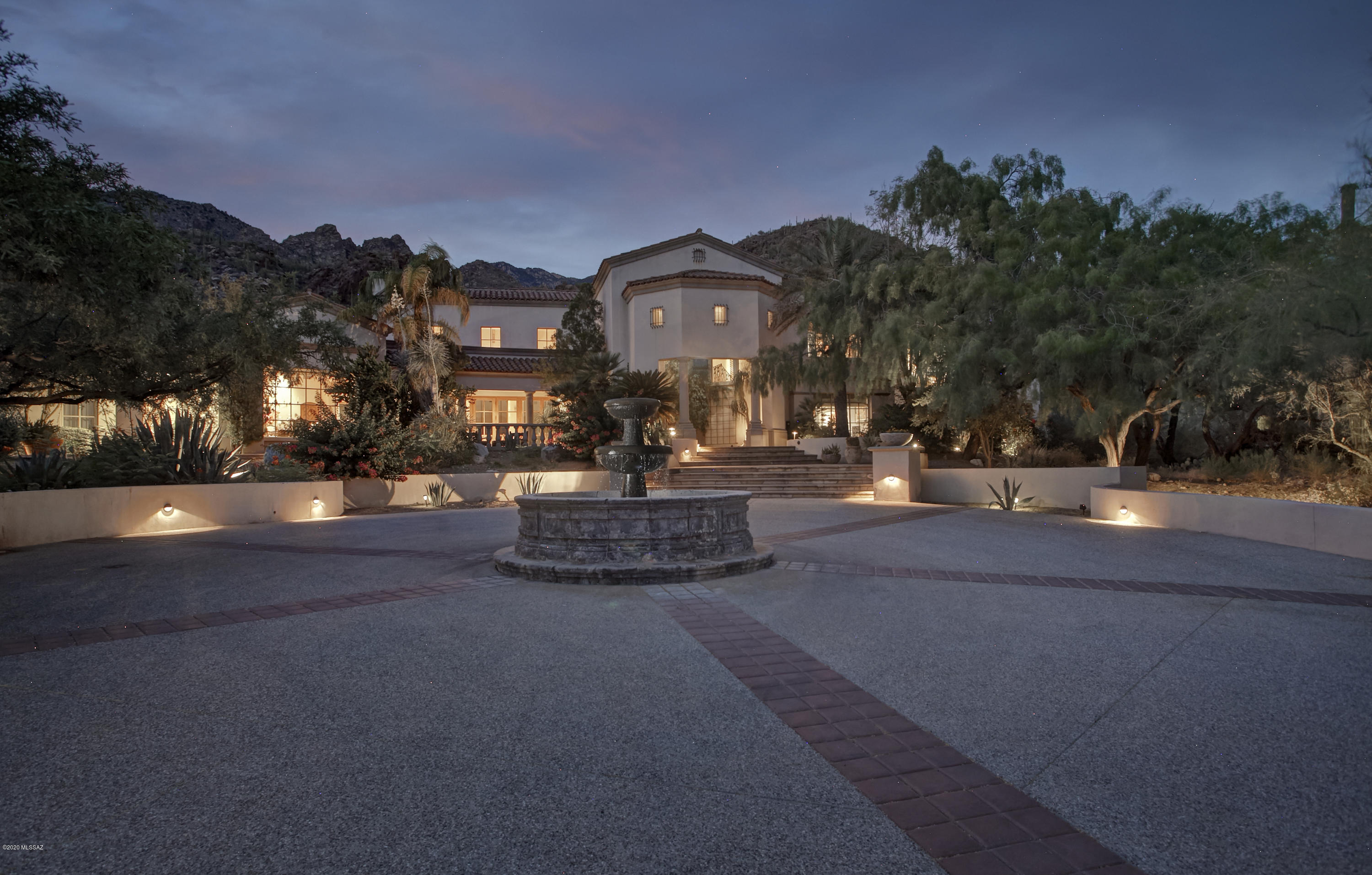 Without question, one of the finest homes EVER to come on the market in the Foothills and the First Time this home has ever been offered For Sale! Timeless Mike Franks designed Spanish Colonial architecture blends seamlessly with Santa Barbara design influences found throughout this beautiful home which was the vision of the current owners who spared no expense in its construction & whose exquisite taste dictated every design feature & handcrafted detail. ''Casa Bon'', nestled on a double lot in Finisterra Estates backing to the National Forest for ultimate privacy, takes advantage of the mesmerizing mountain, city & private canyon views from every room. Inspired by extensive travels to Mexico, the initial inspiration for the home came from a stay at "Camino Real Resort" in Puerto Vallarta and the 20' living room windows are an exact replica, perfectly framing the majestic saguaros towering above. As the house was designed around the grand living room for formal entertaining & large family gatherings, it grew into its current 7,809 square foot, 5 bedroom, 8 bathroom floorplan yet retained a warm inviting feel & great flow creating a comfortable family home. Features include a private home office w/pecan wood floors & custom built ins, a library loft overlooking the living room, "Benny's Bar", an 800 bottle temp controlled wine cellar off the formal dining room, family room w/fireplace & extensive built ins, 2 powder rooms, private exercise room off the master and a gourmet kitchen sure to please any chef w/custom mesquite cabinets & island, butlers pantry w/2nd fridge, silver & china storage, a serving area w/two warming drawers, commercial Viking gas range & built in Sub Zero along with an eat in casual dining area w/fireplace and corner window for morning light. 5 gas fireplaces, stunning intricately cut & laid flagstone floors, Rene Ruvalcaba hand carved doors throughout, a custom Crystal Farms naturally shed antler chandelier from the Royal Herd, 3 car garage w/expansive storage and multiple outdoor patios to relax & enjoy the beautifully landscaped grounds & unrivaled views. Relax in your resort like pool & spa and enjoy all that this magnificent property has to offer as the next stewards of this resplendent home.  Priced aggressively to sell and is sure to please the most discriminating buyer.