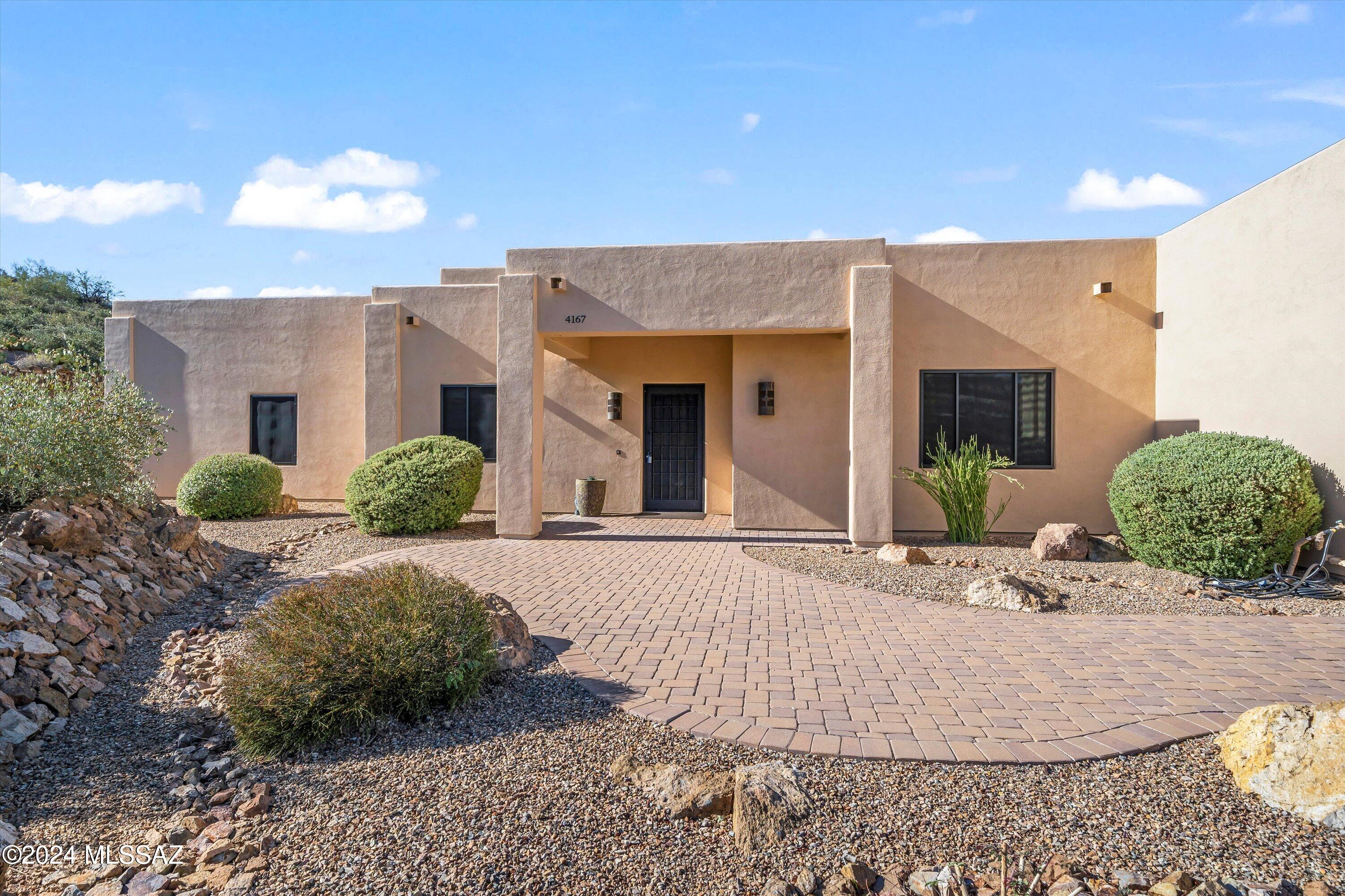 VIEWS VIEWS VIEWS! This beautifully designed west side stunner offers an abundance of upgrades beginning with a  well thought out spacious open floor plan designed with custom steel I-beams in main living area, soaring 14' ceilings, custom steel fireplace mantel and seating lined with facade bricks, huge picture windows with Bulldog security screens, gorgeous scored stained concrete floors throughout, granite countertops, large island perfect for entertaining, massive 48'' and 42'''upper custom cabinets in kitchen that simply add to the grandness. Custom steel exterior doors, massive garages with built in electrical RV hook up and dump station for your convenience with 400 amp service to home. As you step outside to your own private oasis surrounded by serene privacy you won't want to miss those amazing sunsets and picture-perfect mountain views! Sweetwater Preserve the popular biking and hiking area are within walking distance from this home for you avid outdoor lovers. No attention to detail was missed on this home!