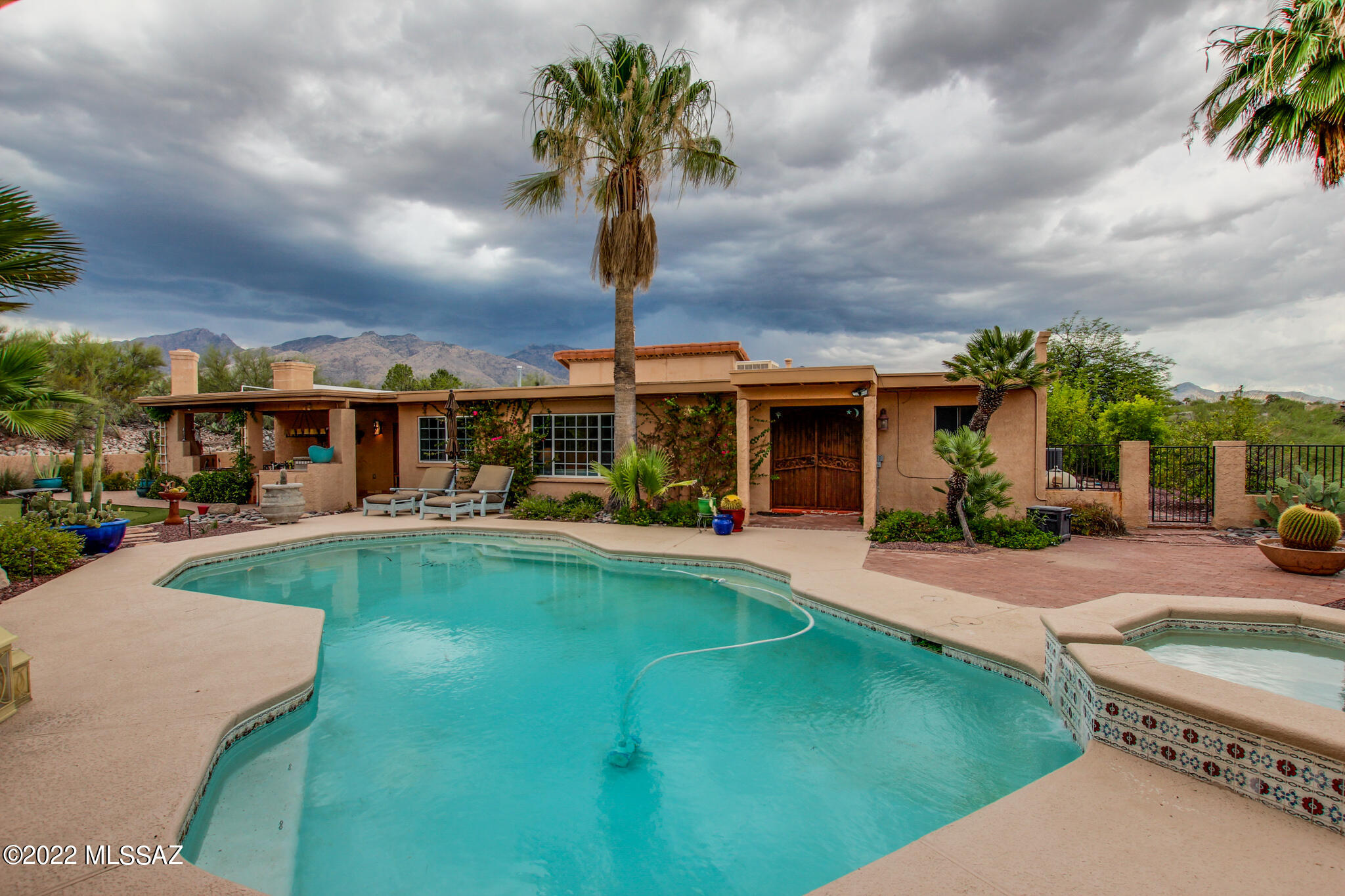 Amazing Mountain Views!! Nestled in the Foothills and resting on the hill top is this beautiful 4 bedroom 3 bathroom home.  Enter thru the Custom (Gated) Winding concrete paver driveway surrounded by lush desert landscaping. Wonderful Great Room with double sided fireplace and formal dining area. Enjoy the spacious family room and cozy up to the Beehive fireplace. The kitchen features a double oven, custom cabinets, gas cook top and SS appliances. Relax in your own private backyard oasis. Splash into the sparkling pool, relax in the spa or practice your golf game at the putting green. The built-in-BBQ and outdoor fireplace is perfect for entertaining. With this tranquil setting and fantastic views, you will never want to leave home. Come take a look!