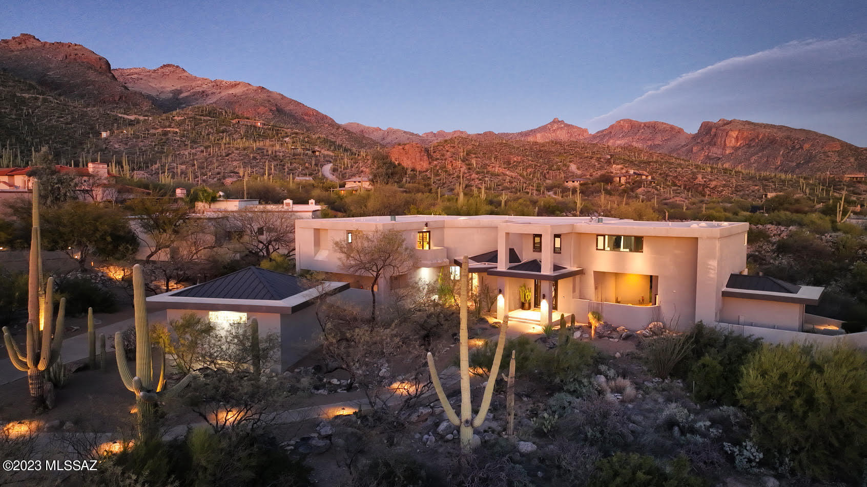 Introducing this grand contemporary estate, designed by architect John Campisano, situated in the highly sought-after Esperero Canyon Estates within the exclusive gated community of Ventana Canyon. This luxurious compound offers a rare combination of privacy, sumptuous amenities, and exceptional style, all on an expansive 1.29-acre lot. This timeless architectural masterpiece features walls of glass that transform almost every room into an open pavilion filled with natural light, inviting you to lounge and enjoy breathtaking views of the surrounding mountains and city. The spacious patios and balconies on two levels are perfect for entertaining, dining al fresco, or simply relaxing poolside. With high ceilings, art-gallery walls, and premium finishes throughout, the main floor is an