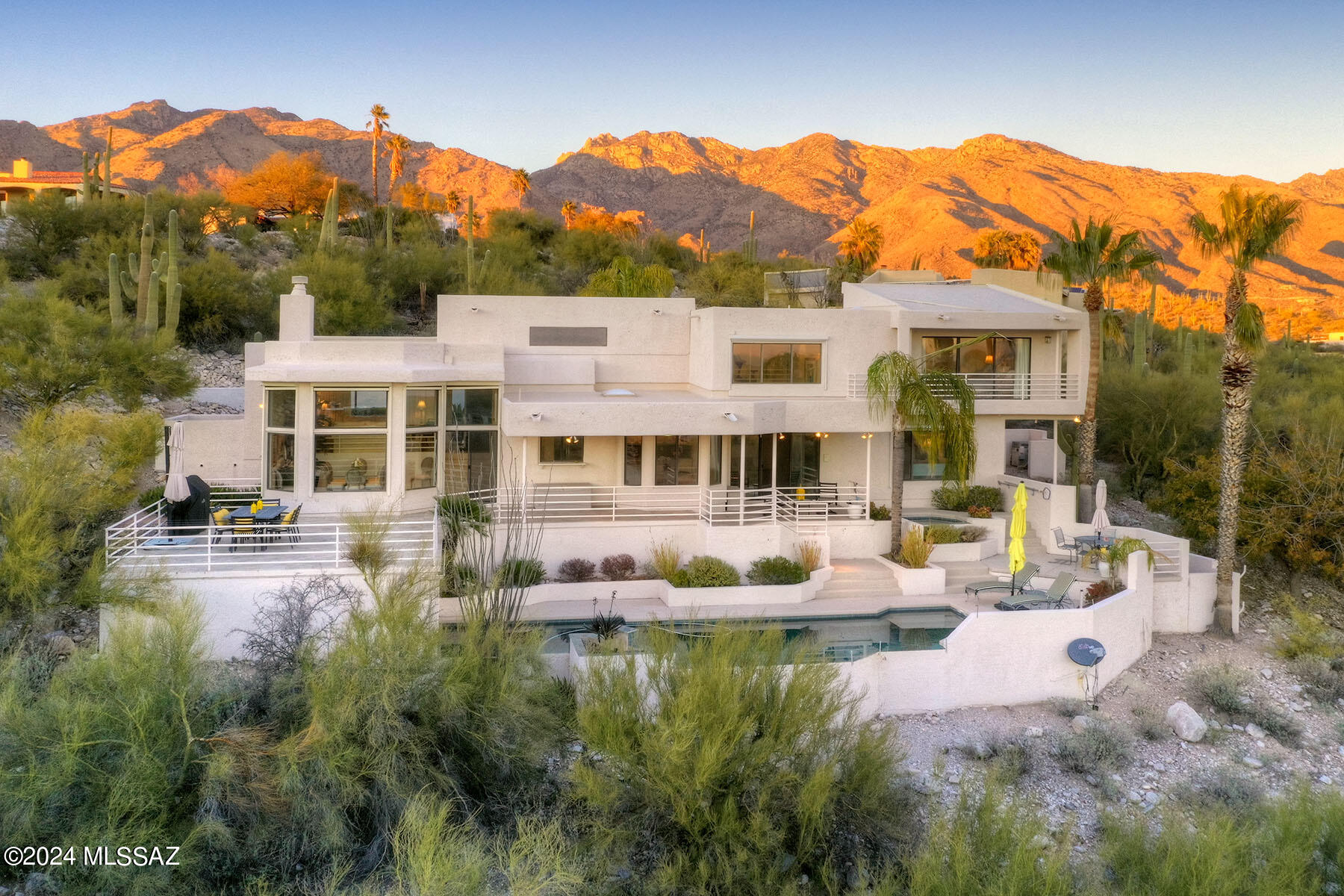 Introducing an exquisite residence nestled in the heart of the Foothills, within the prestigious Cimarron Foothills Estates. This stunning home offers an unparalleled living experience with captivating Catalina Mountain views, city lights and a landscape adorned with majestic saguaros, providing both privacy & natural beauty. Step into luxury as you enter the foyer where you can display your art collection, the adjacent powder room features a stylish vessel sink, setting the tone for the sophisticated design found throughout. The living room is a masterpiece featuring a marble surround fireplace, creating a warm & inviting space. The dining room has wall of windows featuring some of the best views in the house and opens to a large entertaining patio. The kitchen is a culinary haven, boasting upgraded features such as quartz countertops, a central island, and 2-drawer dishwashers for added convenience. A wine cooler adds a touch of elegance, while the cooktop embedded in the island enhances both functionally and aesthetic appeal. The adjacent breakfast nook provides the perfect spot to start your day. Travertine flooring graces the interior, offering a timeless and refined finish. The 3 car garage is not just a space for your vehicles, it's a showcase with epoxy flooring & extra storage, ensuring both practicality and style. The primary suite is a haven of tranquility, featuring a private balcony with breathtaking views. The ensuite bathroom is a spa-like retreat, showcasing a large walk-in shower with a picture window, dual vanities, his & her closets,  bidet, and an  atmosphere of sheer indulgence. Multiple outdoor sitting areas invite you to bask in the beauty of the surroundings. The large entertaining patio is ideal for gatherings, overlooking the infinity pool that seamlessly blends with the landscape. A private spa add the perfect finishing touch to this outdoor oasis. Experience the epitome of desert living in the meticulously crafted residence, where every detail has been thoughtfully considered to create a home that is both luxurious and inviting. Welcome to your sanctuary in the Foothills.