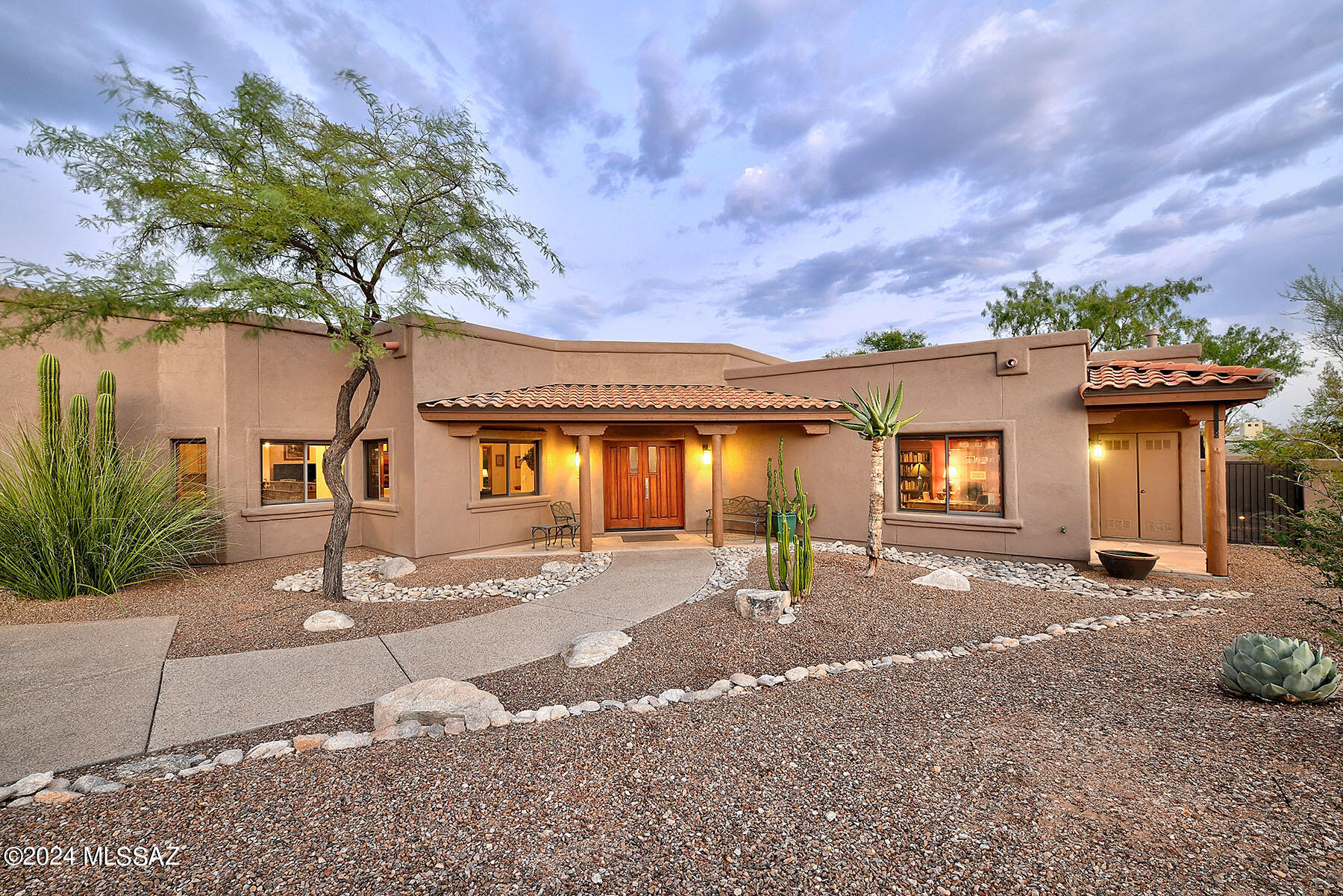 Welcome to this stunning home in the prestigious, gated community of Bellas Catalinas Estates. Set on one of the largest lots, this property offers unparalleled views of the Catalina Mountains and sparkling city lights, creating an idyllic setting for relaxation and entertainment. Step outside into your private oasis, a resort-like backyard featuring a sparkling pool with a cascading waterfall and an elevated spa.  Warm up near the outdoor fireplace while taking in the 3 different mountain ranges. The expansive covered patio, invites outdoor living year-round, surrounded by meticulously designed landscaping that enhances the home's charm. The remodeled interior features a spacious, open-concept design, ideal for everyday living. The dining room is located near the kitchen, and both the family and living rooms are spacious and offer a warm fireplace. The gourmet kitchen is a chef's dream, with an abundance of granite countertops, a large island with prep sink, and top-of-the-line appliances. Whether cooking for family or hosting guests, this kitchen is both functional and stylish. Designed for privacy and comfort, this home boasts a desirable split-bedroom floor plan. The primary suite offers a peaceful retreat with a remodeled luxurious bath and walk in closet. You also find a well-appointed quest quarters, with its own entrance, providing privacy for visitors or multi-generational living. A spacious 3 car garage with extra workshop, provides ample storage, while a circular driveway adds plenty of additional parking space. With its combination of stunning views, luxurious amenities, and custom finishes, this home offers the ultimate in Southwest living.