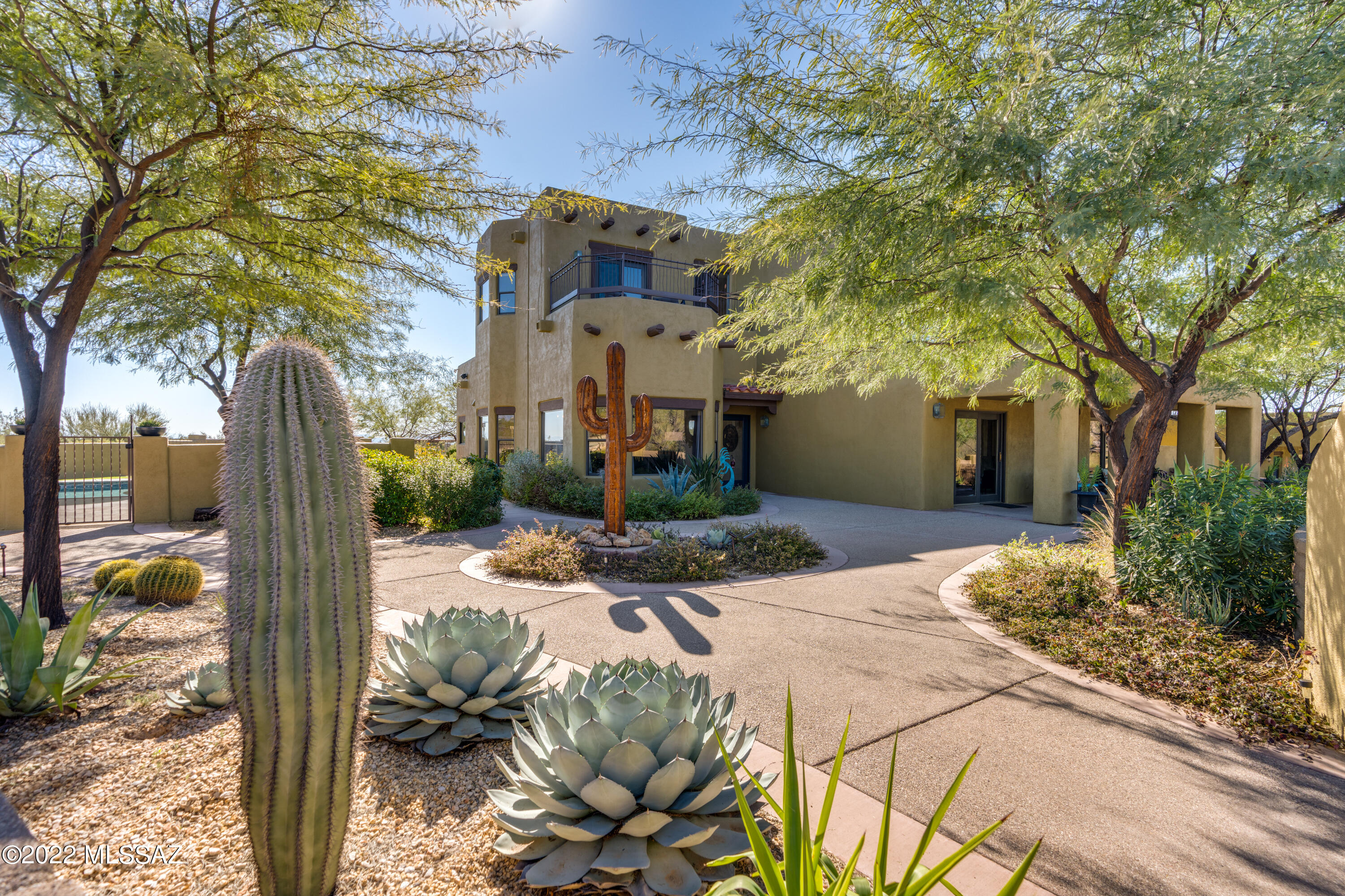 This home truly has  it all!  It is no wonder that it is the WINNER OF THE TUCSON ASSOCIATION OF REALTORS' HOME TOUR AS WELL AS THE ORO VALLEY HOME TOUR! This unique gated and walled estate backs up to the Tortolita Mountains and Saguaro Ranch.  It is on 4.43 flat usable acres and sits at the end of a paved cul-de-sac. Enjoy majestic mountain/city views from EVERY window in the 4,409 sqft main house as well as the detached 730 sqft. Casita. It features a downstairs primary bedroom as well as a 2nd en-suite, upstairs. This home has been meticulously cared for and successfully blends class with the comforts of home.  The kitchen has beautiful granite counter tops and soft-close cabinets.  The large island provides ample space for preparing meals, dining or a computer workspace utilizing the built in pop up charging stand. All 5 bedrooms are nicely sized and provide amazing mountain views.  This home is an entertainer's dream.  Inside, you can enjoy your favorite movie in the media room with theater seating and surround sound!  Practice your golf game from your own tee box & putting greens, splash around in your swimming pool, grill your favorite foods from your outdoor kitchen and watch the quail and rabbits from your screened in AZ room.  You will appreciate the quiet serenity and space and yet be only a few minutes from shopping and restaurants. This home does not have an HOA and the RH zoning allows for horses.   The Casita allows that extra room for out of town friends or family. It has also been used on occasion for income as a vacation rental.  Net income received from the VRBO Casita was just under $25,000 for 2021! 
Views of 3 different mountain ranges are visible from inside and outside of this home.  The 4.43 acres have been landscaped so that there is a nice balance of natural desert vegetation with pathways to several outdoor entertaining areas.  The property includes additional undeveloped land beyond the wall on the North and west sides of the property.  This is a must see property and will not disappoint!