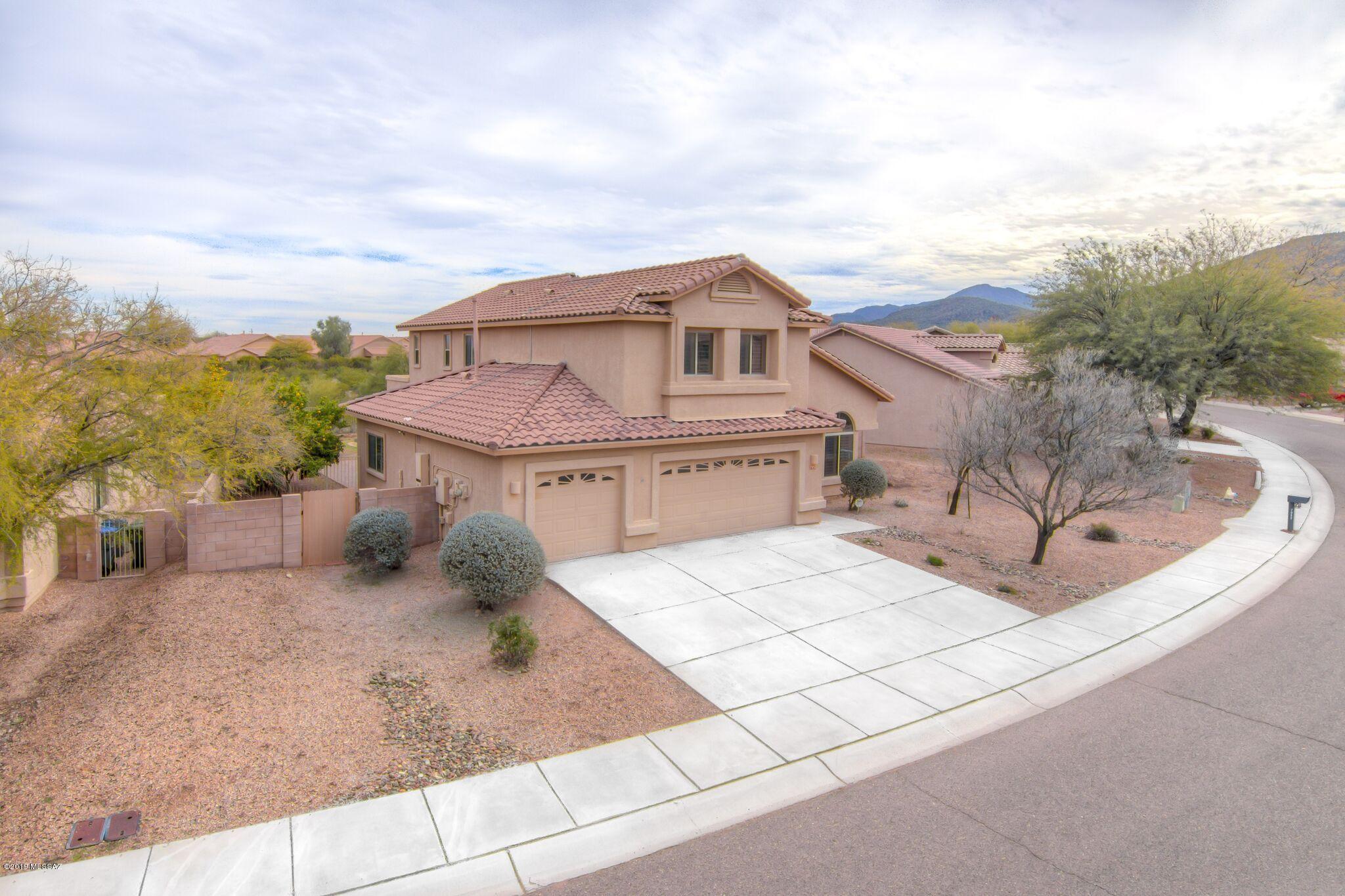 Beautiful and ENERGY EFFICIENT!! This gorgeous 5 bed/3 bath home with 3 car garage is as pretty as a picture as well as being highly efficient with solar heated water, plantation shutters, tinted windows and electric bills that seem impossibly tiny for such a spacious home! 4 bedrooms upstairs including Master en suite and full bedroom and bath downstairs provide the perfect space for a Mother in Law quarters, home office, workout room or any number of possibilities! Chef's kitchen opens to huge family room & features tons of counter space, endless cabinets and storage and a huge pantry! Gas fireplace to snuggle by on the rare cold Tucson night! Outside, enjoy low care yard with grass (in Spring) numerous citrus trees, built in BBQ with prep space and no neighbors behind! Heaven on Earth!!