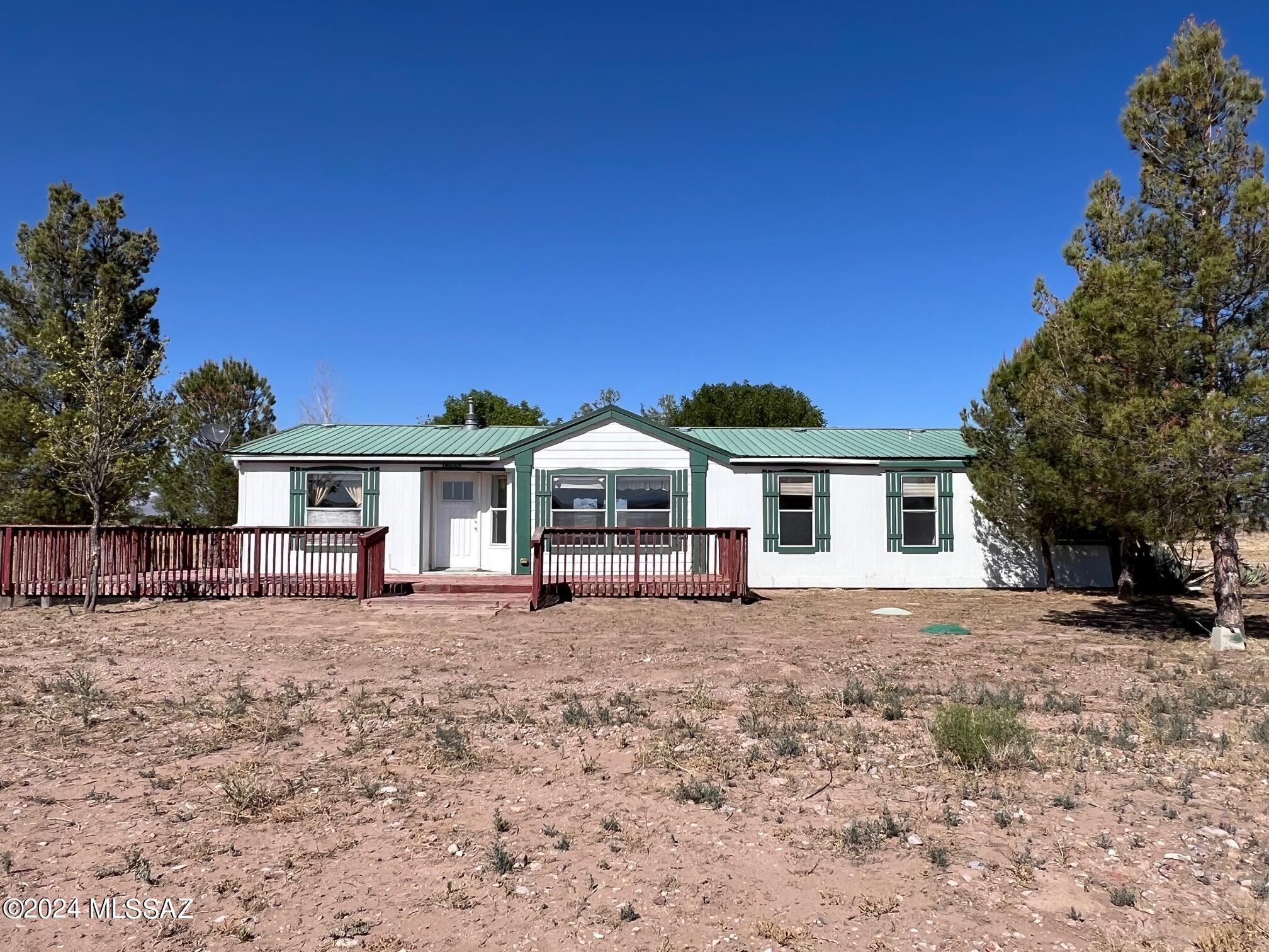 Spacious home (2 x 6 const) with  a metal roof on 17.78 acres plus  an irrigation well. Awesome kitchen, center island provides for a great prep area, lots of cabinets.   Two car garage with a work bench, compressor and   a 6 x 12 attached greenhouse.  24 x 30 steel barn. Small young grape orchard on drip irrigation, 3 different types planted.  Chicken coop  Shaded patio area in back yard. Includes parcel #s 403-27-007G, 007H.