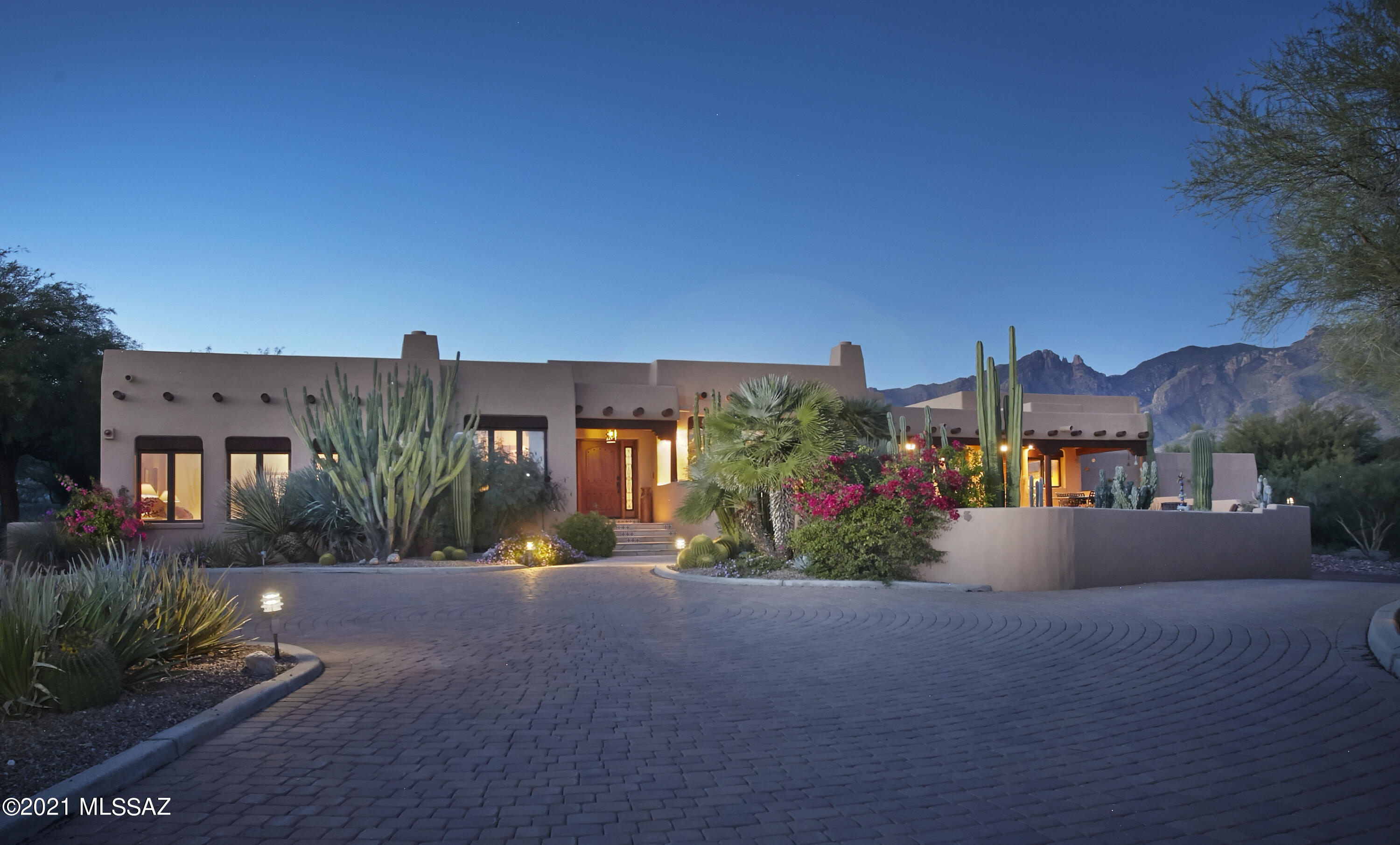 When a current owner's good taste & eye for authentic Southwest design is paired with an original owner's quality construction & architectural vision, the result is nothing short of spectacular. This custom 4,236 sq.ft 5 bedroom, 4 bathroom masonry stucco home, built by respected builder, Mike Wachs for his own personal residence, sits on a prime 1.8ac lot in coveted ''Cat 10'', one of the Foothills most prestigious gated communities.  The current owners, an acclaimed artist and retired engineer, having moved here from Santa Fe, NM have tastefully updated & thoughtfully modernized the home to today's standards without losing any of the authentic Southwestern charm Wachs is known for. As you approach, up the long private driveway, the Catalina Mountains & Finger Rock tower over the house- a sign you have arrived in life & at the right house! "Social Distance in Style" and Work from home in your private home office, located on the opposite side of the house from the kitchen and upstairs game loft! The versatile and well thought out floorplan can easily transform this spacious family home into a casual but elegant entertainers dream home, perfectly suited for an empty nest couple, effortlessly. As you enter the home, your eyes are immediately drawn to the inviting living room w/a wall of built ins to display a large art collection and treasures from your world travels.  You will also find a corner gas fireplace and a wall of windows perfectly framing the city lights, lush desert landscape and exotic cactus gardens by Plants of Distinction. When guest arrive, they will no doubt find their way to the heart of any home, the kitchen! Here you will find newer stainless appliances incl a Wolf cooktop, double ovens and a large center island, stunning granite counters and a breakfast area w/banco seating. Off the kitchen is the formal dining room and adjacent bar w/wine fridge; sure to get some use during the holidays! The master bedroom suite features a double-sided fireplace, reading alcove, walls of windows and a spacious spa like bathroom w/large Jacuzzi tub & walk in shower. On the main level you will find another guest bedroom w/private bath currently being used as an art studio, an enormous laundry room/butler's pantry and a stylish powder room. Upstairs you will find a bonus loft/media area in addition to two spacious bedrooms with large walk-in closets, impressive mountain views and a shared bathroom with double sinks, hand painted Talavera tile countertops and accents. The beautifully landscaped pool area and lush desert grounds surrounding the home are complimented by exotic specimen cactus & native plants for low maintenance & water conservation.  Oversized three car garage could easily accommodate a small RV or hydraulic lift for additional car storage and workshop.