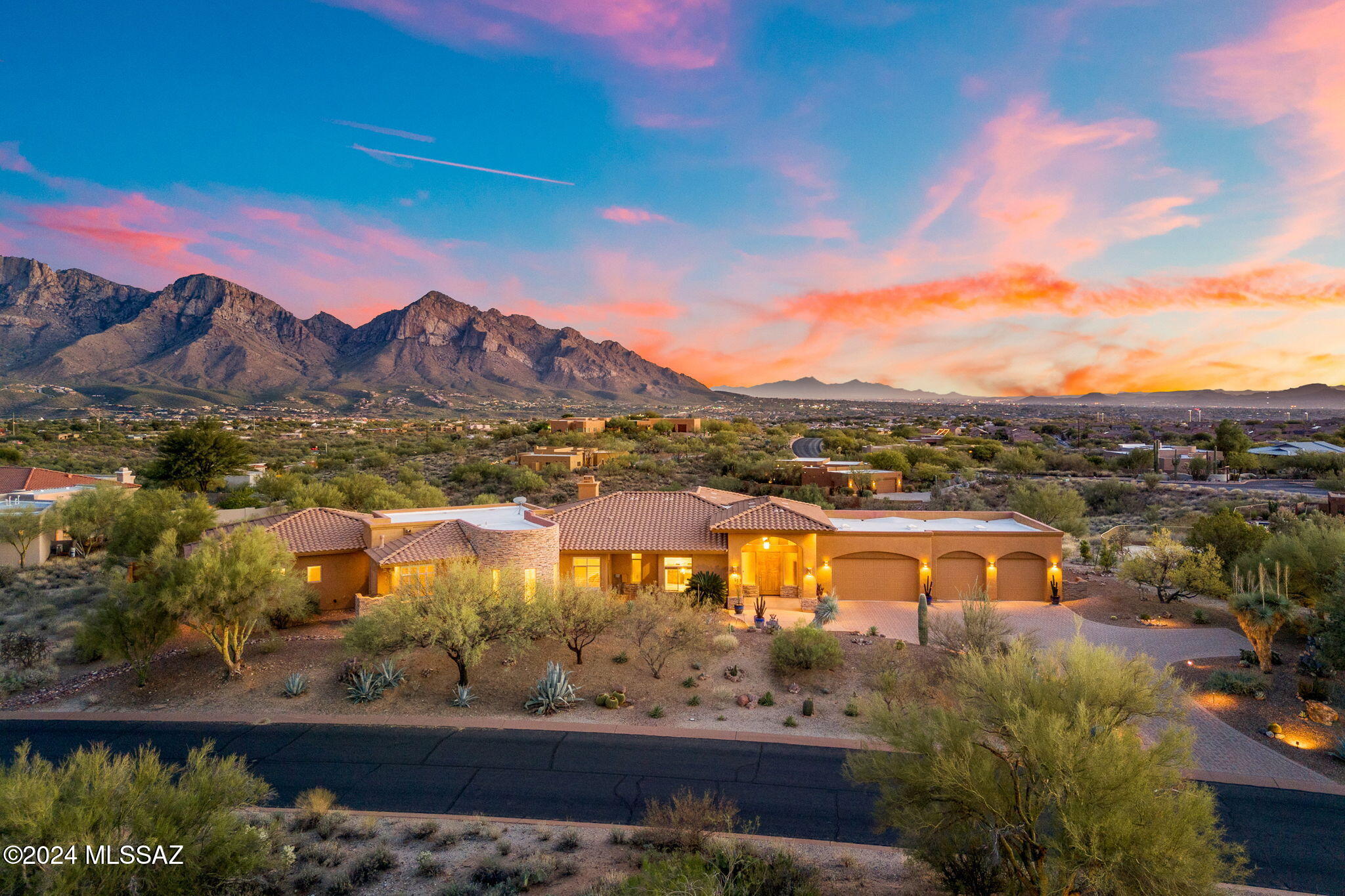 This sprawling, 4100 sf custom hacienda on 1.13 acres in coveted Coyote Ridge in the heart of Oro Valley boasts STUNNING mountain and city views! Step in and experience old world classic Tucson living the moment you enter the impressive foyer. You will be guided into the great room with picture windows and VIEWS at every turn! Expansive gourmet kitchen with granite counters, center island, stainless steel Viking appliances, and thoughtful features such as a pot filler and wine cooler. Beautiful wood beam ceiling in the formal dining room (currently being used as a game room) and a great room with a charming beehive gas fireplace. There is ample space for all with an oversized primary ensuite, two additional bedrooms and baths, an exercise/flex room, a den and don't forget the spacious 4 car garage (1400 sf!) with epoxy floors to comfortably house all your toys! The home is designed around the custom pool with water feature and hot tub and you will also find a firepit, outdoor kitchen, seating area with misters, and productive fruit trees as well as a small private pet area. The private lot creates a serene ambiance, and makes this home one you will never want to leave! Close to schools, shopping, restaurants and more, this home showcases an authentic Tucson experience!