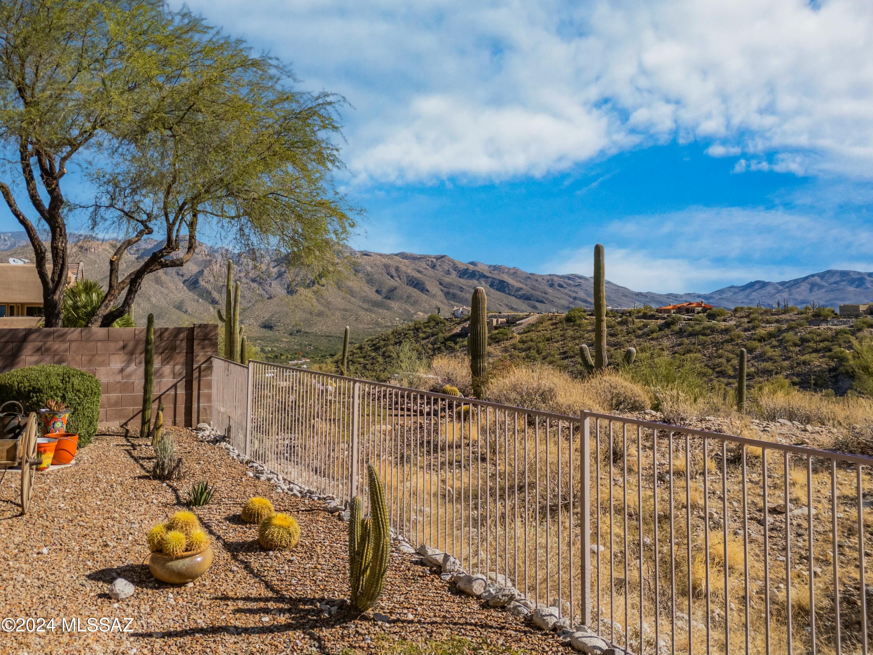 OPEN HOUSE TODAY DEC 8, 12 - 3 PM. NEW LOWER PRICE. Welcome to gated Sabino Mountain, & 50 miles of unobstructed views of the Catalina, Rincon & Santa Rita Mountains, valley views & city lights. Dramatic circular foyer greets your guests, upgraded ceramic diagonal tile & high ceilings. The kitchen is a chefs dream, plenty of counter space, 42'' upgraded cabinets, decorative countertops & backsplash. Note beautiful maple wood floors/Brazilian cherry wood trim! Upgraded master bath, marble shower & countertops &  a WOW factor. east facing back patio presents a shaded &  cooler summer BBQ opportunity; one mile away is hiking in world famous Sabino Canyon. The night city lights of Tucson are a carpet of diamonds. Close to fine dining, shopping, medical... everything! A home to be proud of!