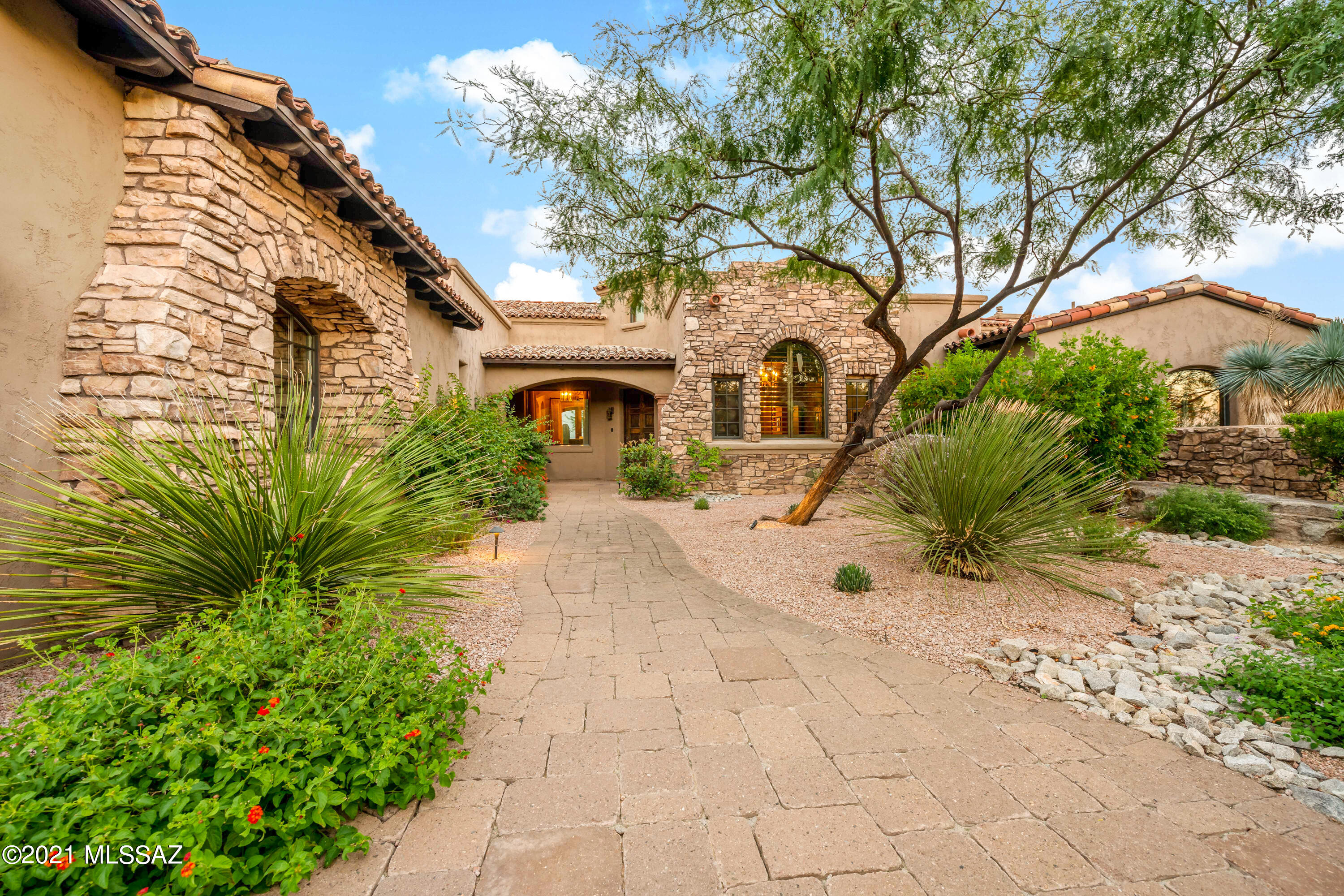 Hacienda Bella Vista - Tuscan Estates in Stone Canyon presents this hilltop home with miles and miles of views of the beloved Catalina Mountain Range to Downtown City Lights.  The perfect split floor plan with 2 Master Suites in the main house including Den/Office AND incredibly spacious detached Guest House.  Guest House layout offers a spacious Sitting Room, Large Bedroom and Bathroom.  Beautifully appointed inside with superb quality construction such as masonry built frame, elaborate timeless light fixtures, organic materials include stone floors, high end granite, knotty alder solid wood doors, and viking/subzero appliances. Large covered East facing patio is private and allows you stunning views and elevation. Enjoy the water fall which leads you into the private hot tub. Stone Canyon is a private golf community. Sports Membership is a requirement.