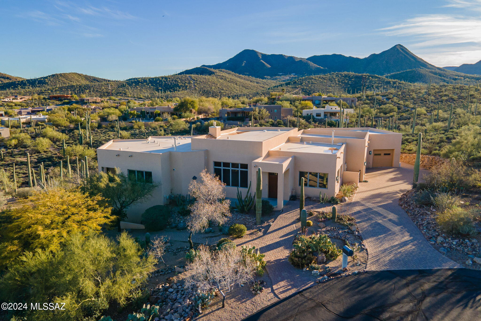 Located in the highly desirable gated, westside neighborhood, this custom southwestern contemporary split-level home sits on 2+acre saguaro studded hillside cul-de-sac lot w/breathtaking views from every window & patio. Beautiful Jos Villabrille mural paintings bring the best of the Sonoran landscape to life inside. Primary suite, two half baths & large bonus room/office/studio on main floor. Lower level provides 2 private suites, walk-in closets, jack & jill bath, separate vanities, & additional living space-perfect for multi-generational use or for guests. Pool w/rock waterfall. 2 car garage+1 car w/ lg workshop-ideal for artist, woodworking, auto shop-plumbed air compressor, 220v, electrical panel, workbenches, utility sink, mini-split. Easy access to I-10/ UA/Airport/DM/Raytheon