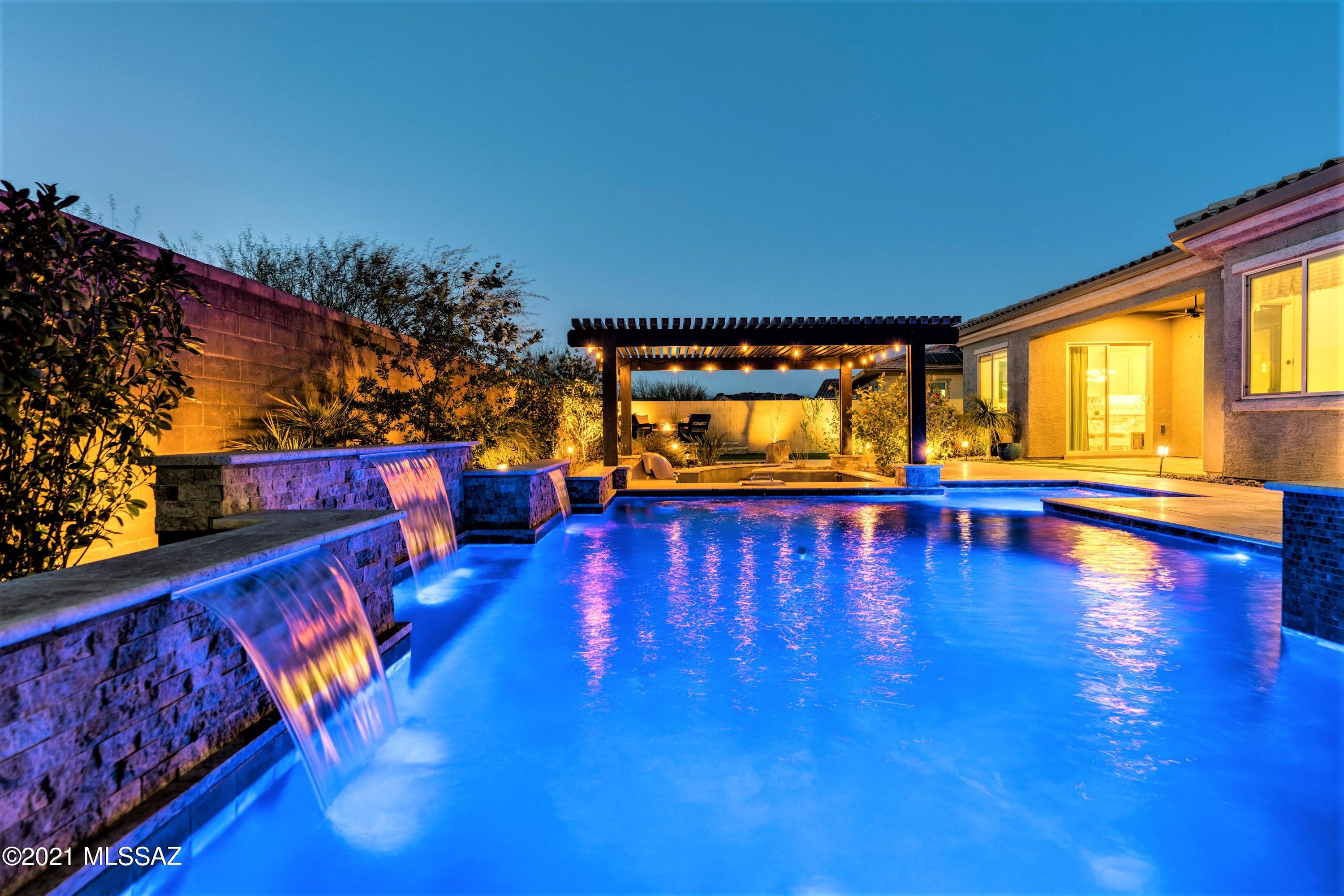 Stunning home located in the prestigious, community of Center Pointe Vistoso. Open gourmet kitchen with gorgeous granite counters, SS appliances, custom lighting, gas cooktop with pot filler, dual ovens, new backsplash, newer smart fridge & silent dishwasher. Luxurious outdoor space with custom salt water pool, spa, swim up bar, sunken kitchen with bar & built in grill. Relax around the gas firepit. Custom blinds & ceiling fans, designer lighting, laundry room updated with utility sink and California Closets & shelving. Illuminated landscaping. Spacious master suite, soaking tub, walk in closet with built-ins. Den/office with granite topped bar and 2 beverage fridges. 3 more spacious guest bedrooms. OWNED SOLAR & soft water systems! Too many amazing features to list. Come see for yourself!