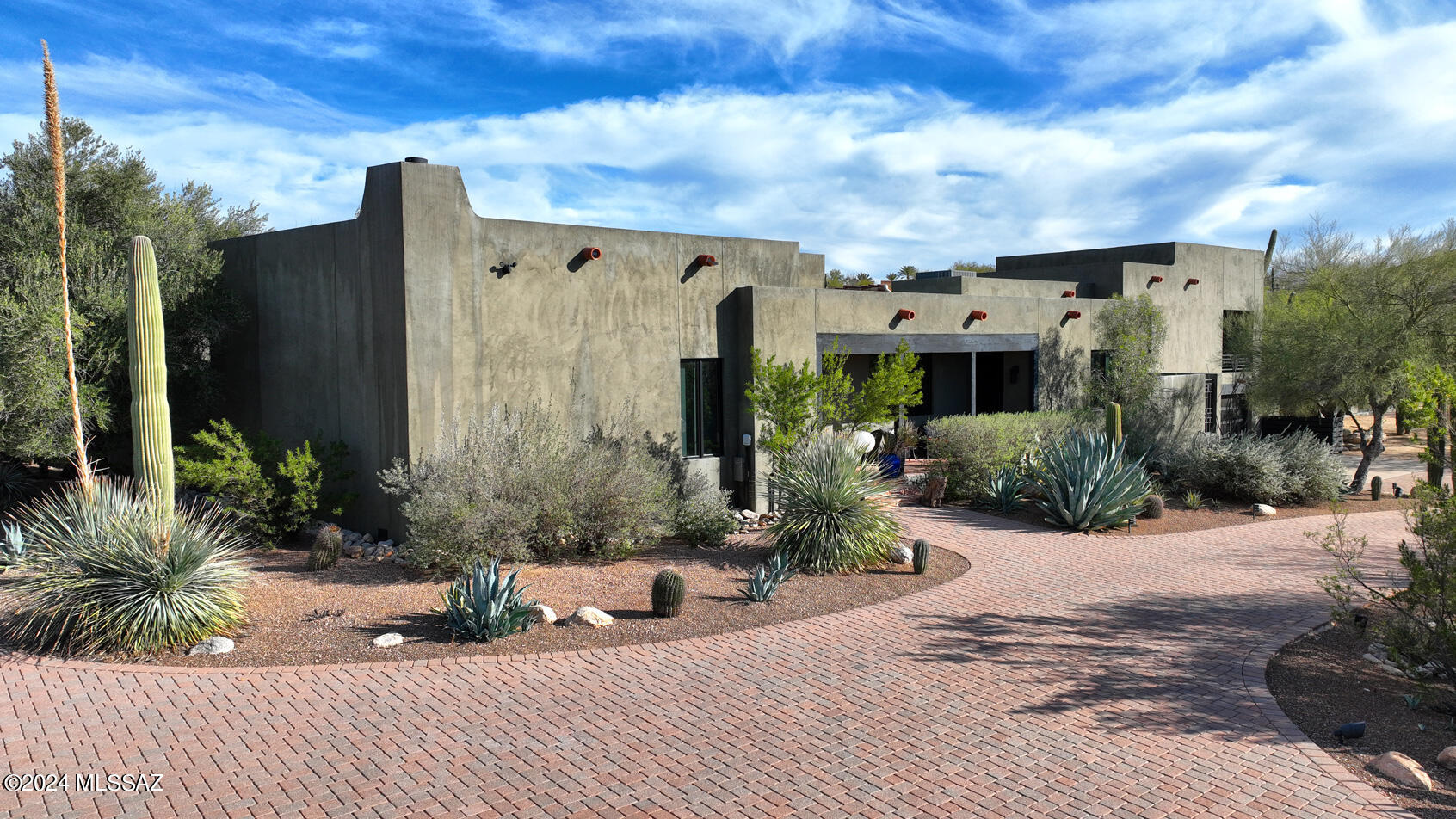 Situated in the private enclave of Cobo Catalina Hills on a secluded parcel just west of Pima Canyon. Enjoy privacy as you blend into the desert surroundings on this lush scenic 5 acre parcel. Designed by architect Abbott Harle as his personal residence offering an easiness and friendly ambiance, views surround you at every turn with large picture windows capturing mountain views and city lights beyond. Separate guest house flanks the pool area, with a series of elevated french doors spilling out onto the grounds. This home features 4 bedrooms, and 3 baths, wine room, bedroom balconies a stunning kitchen. One of a few with  A 6 CAR GARAGE, Totem Pole does not convey. Pls note 5 steps up to master bedroom.