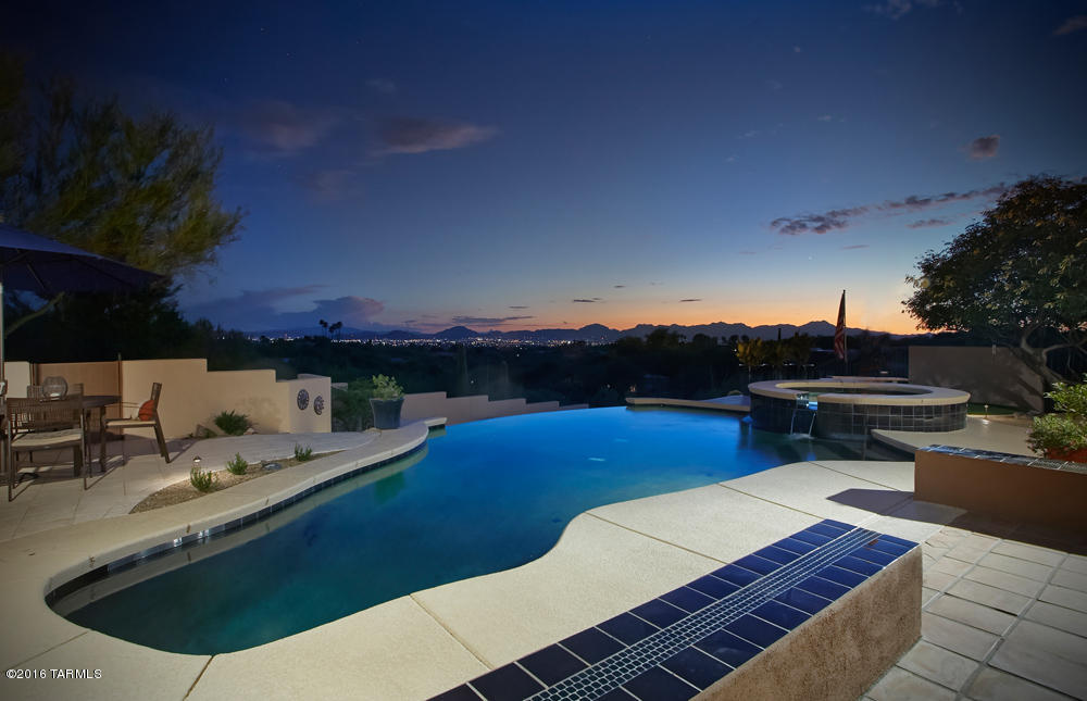 Contemporary 4BR, 3BA in Catalina Foothills Estates, designed and built by acclaimed architects Tyson and Murphy.    Elegant great room w/ 13-foot exposed wood and beam ceiling, features custom Saltillo tile floors and FP.  Property offers space for entertaining and family enjoyment with expansive views of both the Catalina Mountains and the Tucson city lights.  Patio and pool area was extensively redesigned and rebuilt in 2016 to take advantage of the hillside setting with tiered seating and dining areas.  Master BR w/corner window wall frames view of city lights.  Kitchen opens to both the great room and family room and features a hand-painted Mexican mosaic tile, SS appliances, and ample pantry storage. Convenient to shopping, upscale restaurants, art galleries, District 16 schools.