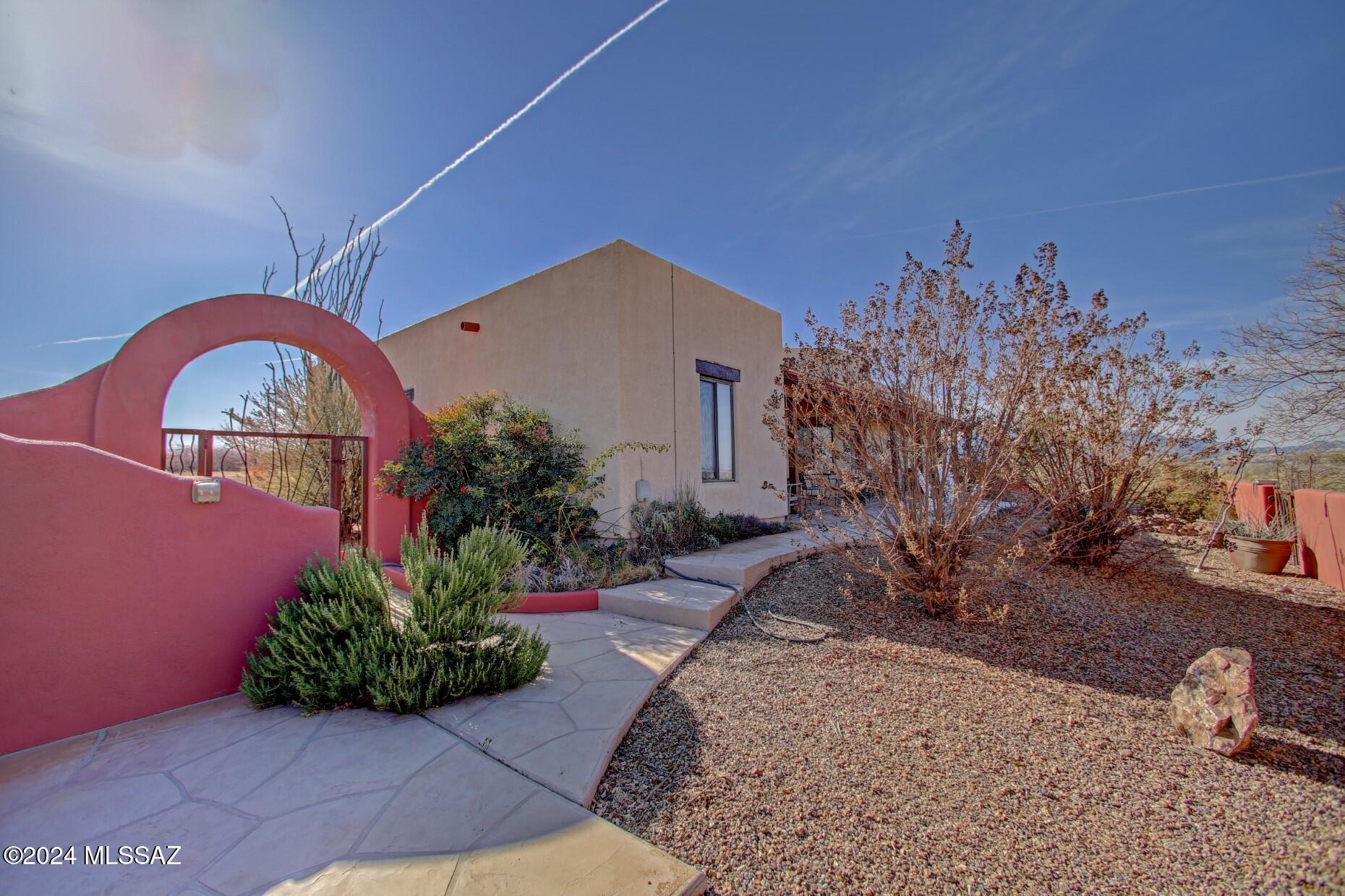Gorgeous Southwest Custom Home Includes a 1011 ft Workshop/barn with a semi wrap covered porch & 1 roll up/2 pass thru doors, tack/storage room, attached dog kennel & Amazing Views. Design features include striking cedar wood plank ceiling & exposed pine vega beams, handcrafted kitchen cabinetry w/inlaid saguaro rib detail, saltillo tile flooring, solid mesquite wood flooring in primary bedroom w/walk-in closet, custom wood front entry door & high ceilings. Lovely wood fireplace w/large hearth, iron crafted hardware throughout, double doors leading to covered back patio & walled court yard w/custom ornamental iron gates, wonderful garden plantings & solar front entry gate. Property is completely fenced for animals to freely roam. Large metal water harvesting storage tank and a private wel