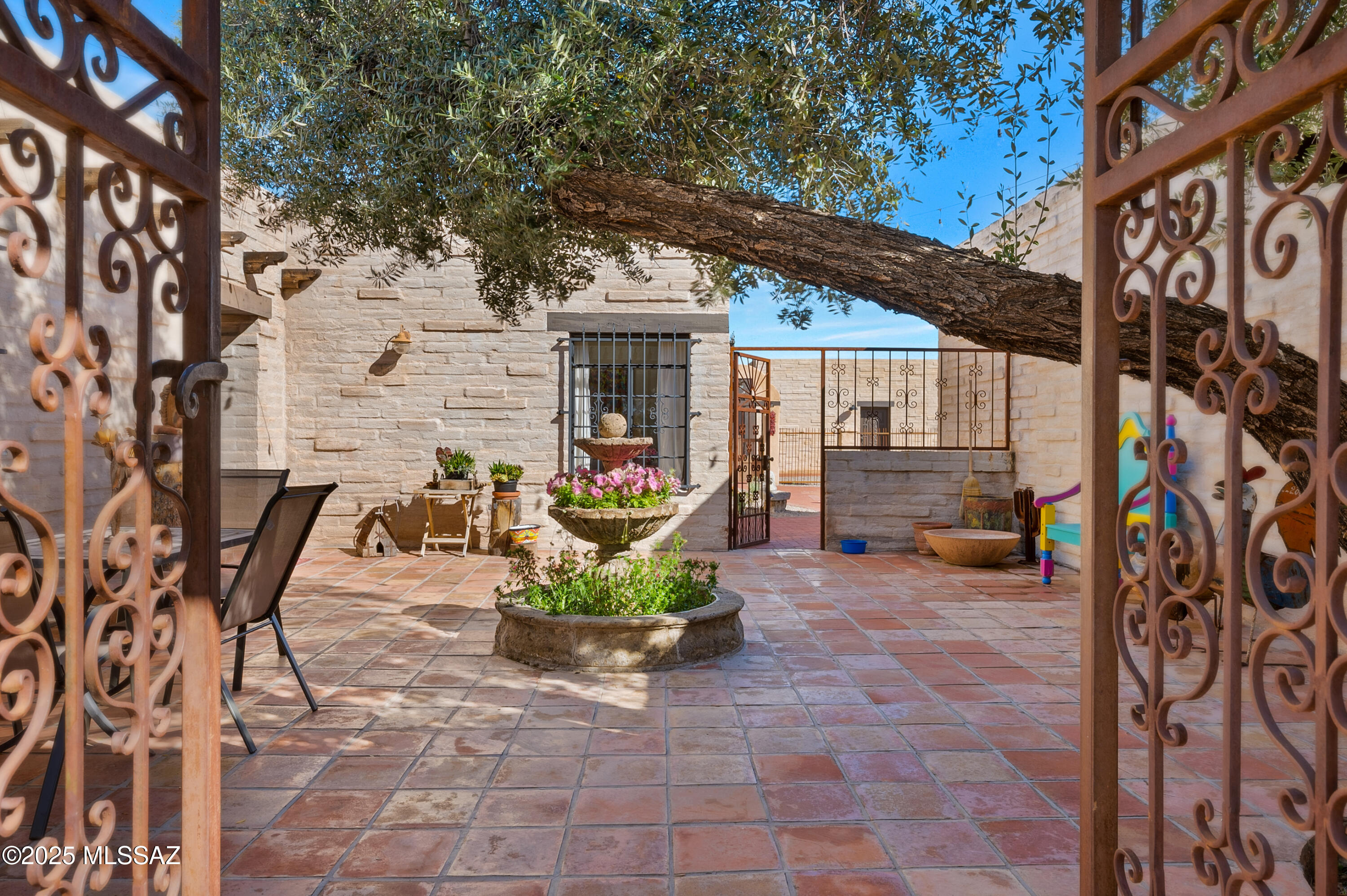 Architecturally Significant Rillito River Hacienda with Panoramic Views and Enduring Charm! Designed by renowned Tucson architect and artist Warren Edminster, this iconic estate on 3.3 lush acres along the Rillito River blends timeless Spanish hacienda architecture with tasteful modern updates and breathtaking mountain views. From the moment you enter through the electronic gates, the setting makes a lasting impression—majestic eucalyptus trees, native desert vegetation, and dramatic Catalina Mountain views surround the property with natural beauty & serenity. These trees attract nesting great horned owls, red-tailed hawks, and a variety of songbirds, while local wildlife including bobcats, javelina, & coyotes can be seen meandering nearby, making this property a peaceful haven for natur lovers and birders alike. A charming courtyard framed by custom wrought iron gates leads you to a beautifully carved front door, setting the tone for the handcrafted elegance found throughout the home.
The 3,541 sqft burnt adobe main residence and 992 sqft remodeled Guest Casita are rich in authentic detail, featuring thick adobe walls, handcrafted Talavera and Saltillo tile, beamed ceilings, copper accents, and custom built-ins.
The spacious great room with a classic beehive fireplace opens to a generous dining area, perfect for gatherings. A separate gallery-style hallway provides space to showcase art and leads to the guest bedroom wing. The custom kitchen features granite countertops, a Talavera tile backsplash, a gas stove with a striking copper hood, a furniture-style island, and an abundance of storage, offering both warmth and functionality.
The primary suite is a serene retreat with soft morning sun from the east and sweeping Catalina Mountain views to the north. It includes a renovated bathroom, custom walk-in closet, and direct access to the backyard. Two guest bedrooms with large closets and deep window seats accented with colorful Talavera tile share a full bath and powder room.
At the rear of the home, the sun-filled Arizona room, once an artist's studio, opens to a large patio ideal for entertaining or simply enjoying the panoramic views and desert setting.
The detached 992 sqft Guest Casita has been beautifully remodeled and is full of charm. The kitchen offers bright, cheerful colors, stainless steel appliances, a breakfast bar, and Saltillo tile and concrete floors with Talavera tile accents throughout. With one spacious bedroom, a full bath, cheerful south-facing windows, and access to both the courtyard and a large side yard, it's ideal for multigenerational living, guests, or short-term rental opportunities. Your guests may never want to leave!
Recent upgrades include all new windows for enhanced efficiency and light, along with a newly constructed oversized 3-car garage featuring an insulated storage room, perfect for a workshop, gear room, or creative studio.
With direct access to The Loop trail, Rio Vista Natural Resource Park and the Tucson Racquet Club, this home offers exceptional convenience in a setting that feels worlds away. Biking access to Trader Joe's, St. Philip's Plaza, and nearby horse boarding facilities with access to miles of riding add to the lifestyle this property affords.
Homes with this level of architectural integrity, natural beauty, and livable charm are rare - this is truly one of Tucson's most treasured estates.