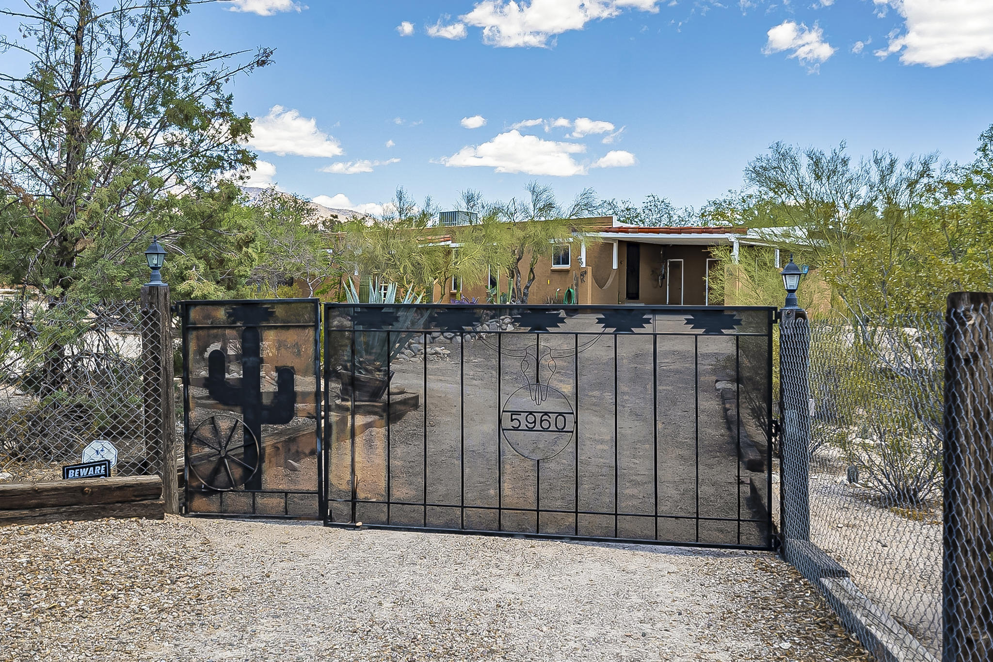 Privacy and nature abound at this beautiful North Tucson home on a .83 acre lot with the perfect amount of Southwest charm, including gorgeous Saltillo flooring, wood-beamed ceilings, and a cozy beehive fireplace with tile accents. Fantastic split-bedroom floor plan with 4 spacious bedrooms, 2 bathrooms, and 2,099 sq.ft. French doors lead to the large covered back patio and backyard with mountain views, ramada, and tortoise habitat. Ample storage inside and out, including a large storage room and closet off the back patio, closets off the carport, and a large storage shed. Triple-pane windows; seamless gutters! The property is completely fenced and landscaped with paths, railroad ties, mature desert plantings and trees, and plenty of room for an RV, horse facilities or other possibilities.