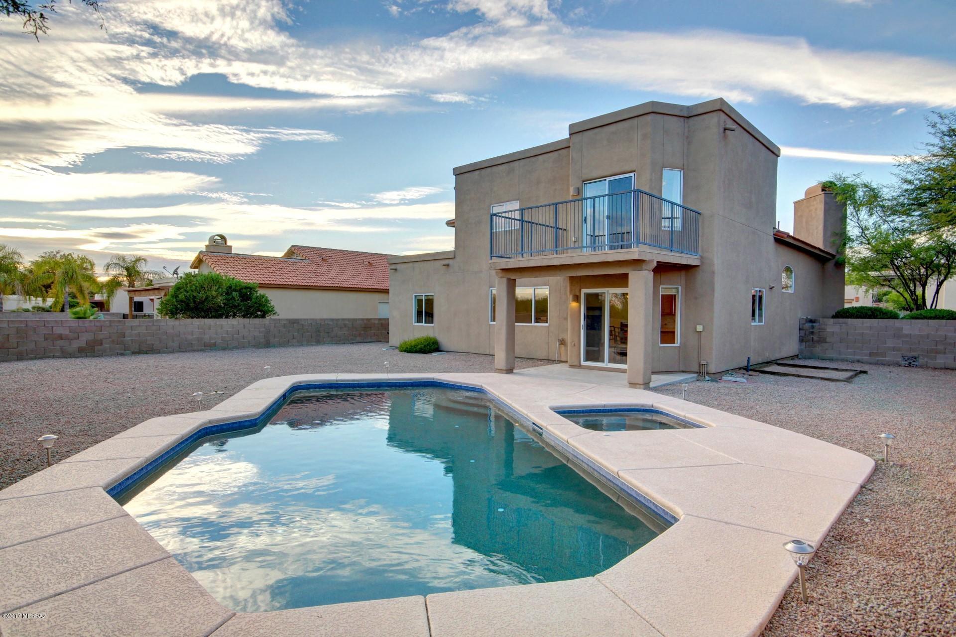 Warm, inviting and ready to help create your memories, this stunning contemporary is nestled on a fabulous and unique premium lot. Breathtaking Pusch Ridge mountain views are yours to enjoy over morning coffee and evening sunsets. Outdoor living awaits with your sparkling heated pool/spa (refinished pebble tec) and abundant space for your imaginative landscaping design. Updated custom kitchen with gorgeous diamond maple cabinets; dove tail, soft close, lazy susans, SS appliances with granite counter-tops complete the warmth of your kitchen designed to endear the chef in the family! Walls of windows face the mountain views for that serene feeling. Bring on the warmth with a gorgeous fireplace and dynamic staircase going upstairs. Guest room is downstairs, with master retreat upstairs.